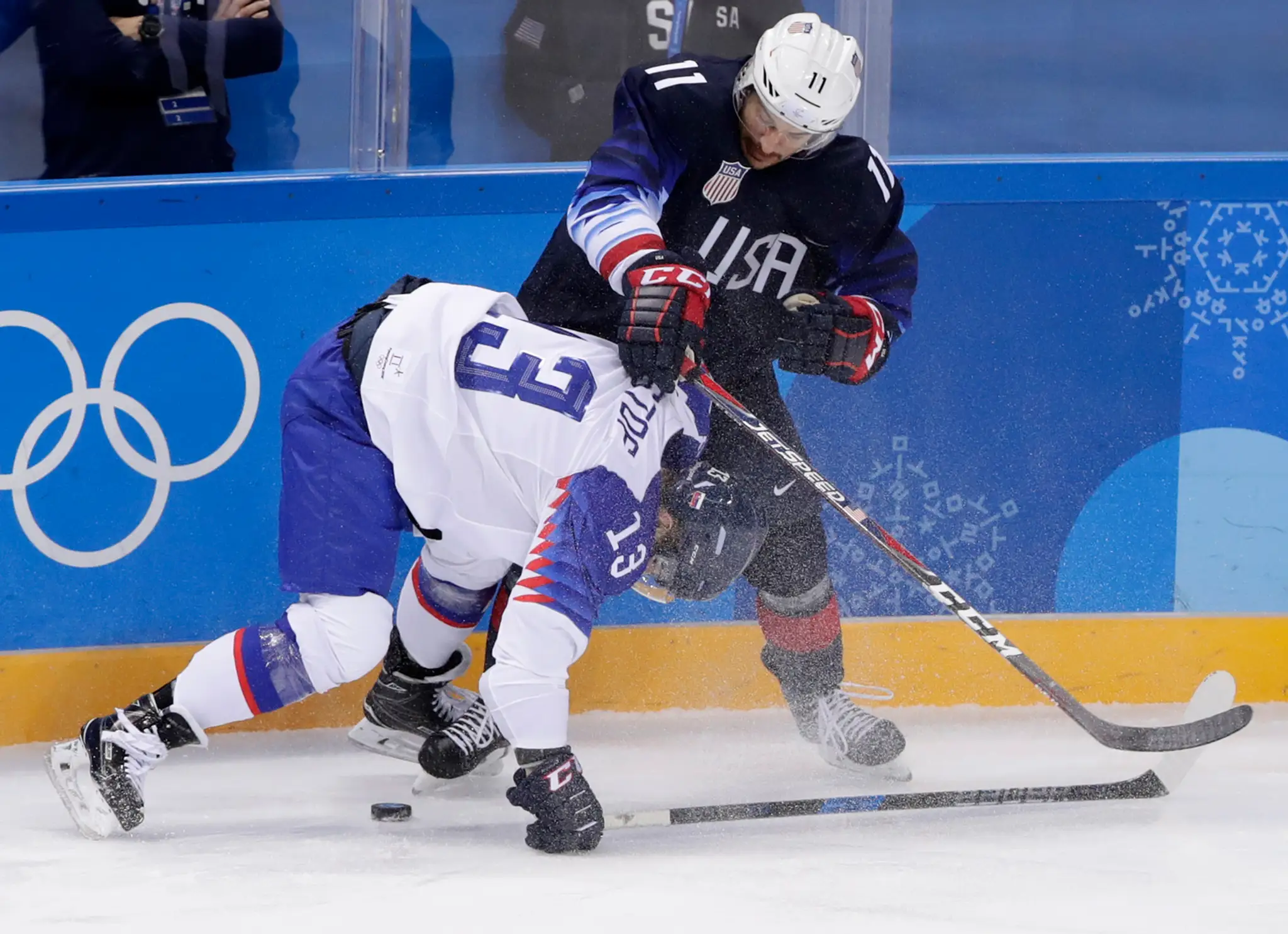 Gólman Slovenska Ján Laco chytá puk pred Troyom Terrym z USA v dueli na ZOH 2018.