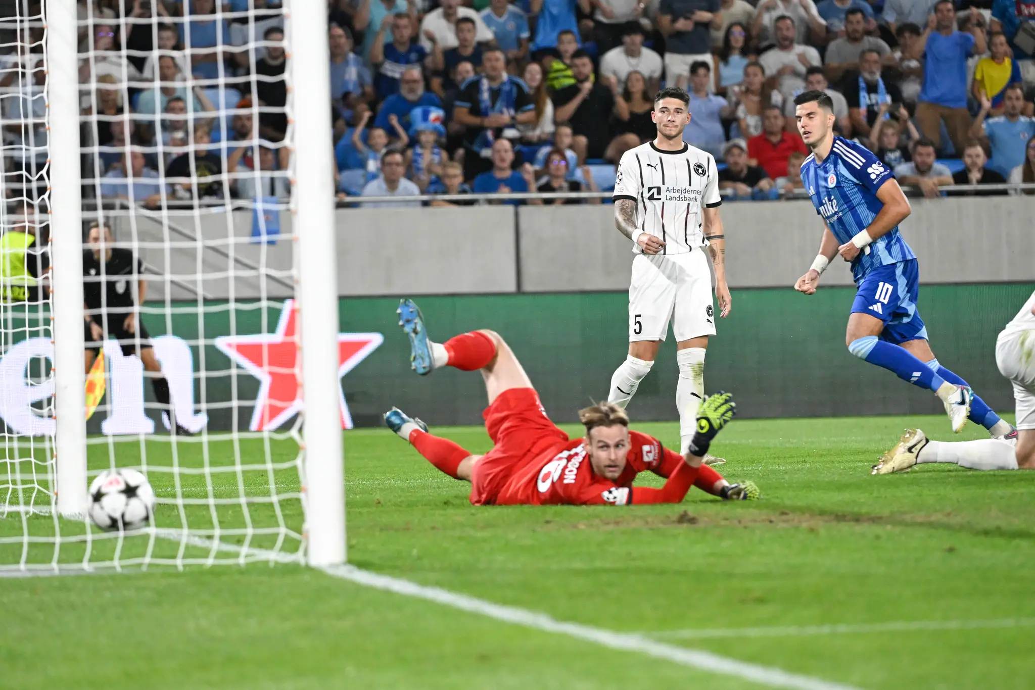 Na snímke vpravo Marko Tolič (Slovan) strieľa gól brankárovi Eliasovi Rafnovi Ólafssonovi (vpravo Midtjylland).