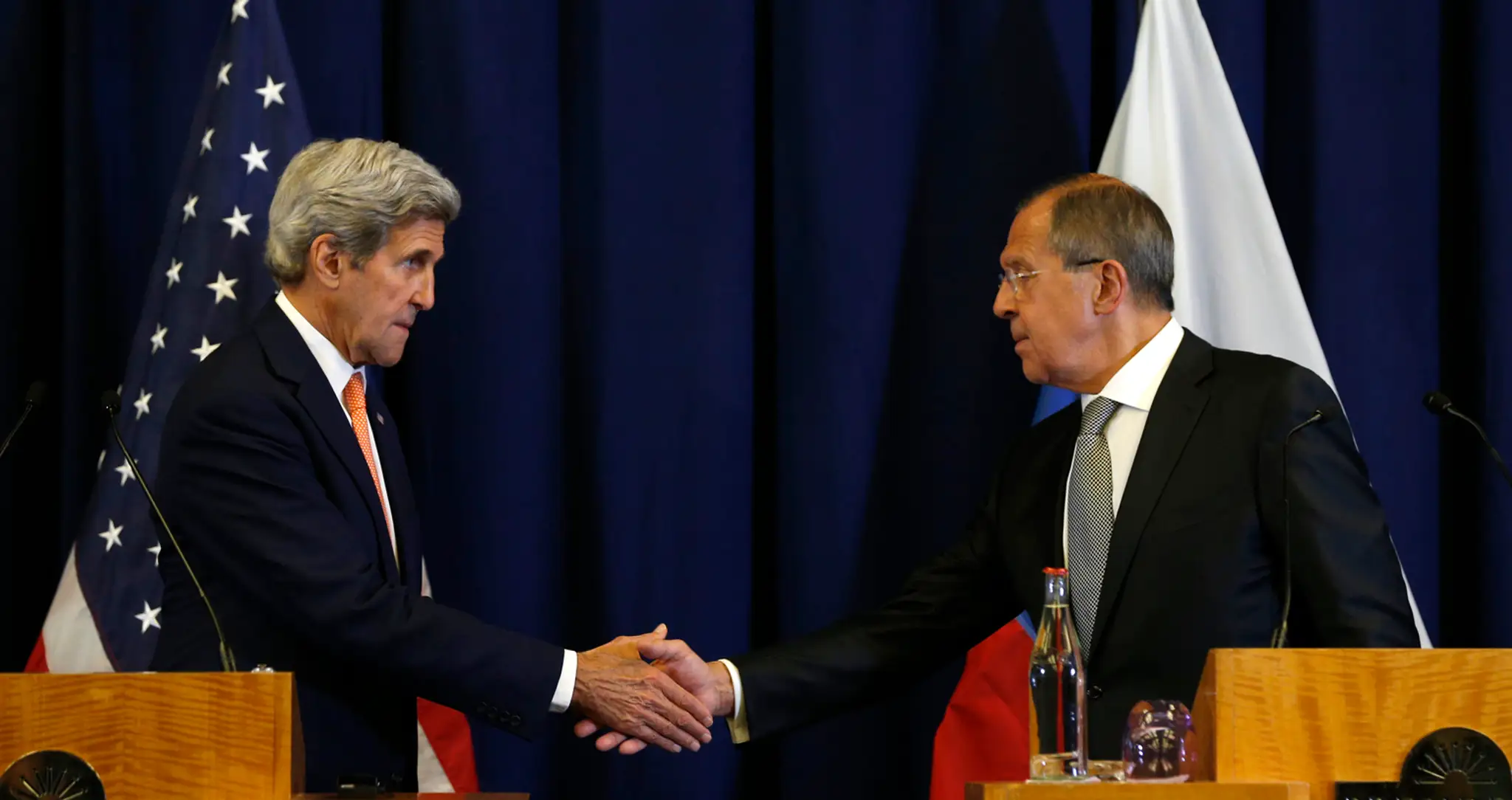 John Kerry a Sergej Lavrov si podávajú ruky po podpísani dohody o prímerí.