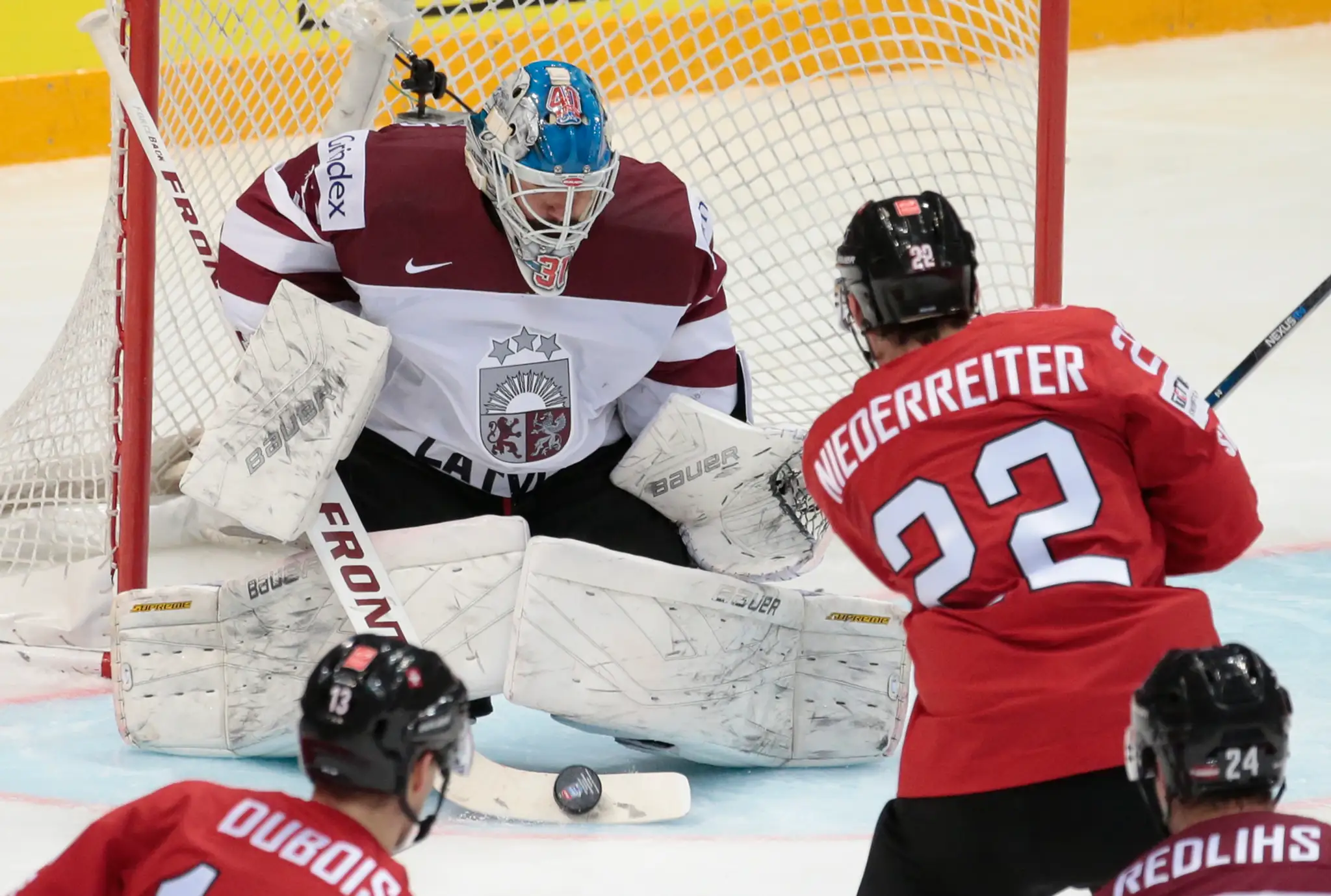 Na snímke vpravo hráč Švajčiarska Nino Niederreiter strieľa gól, vľavo lotyšský brankár Edgars Masalskis počas duelu na MS v Rus