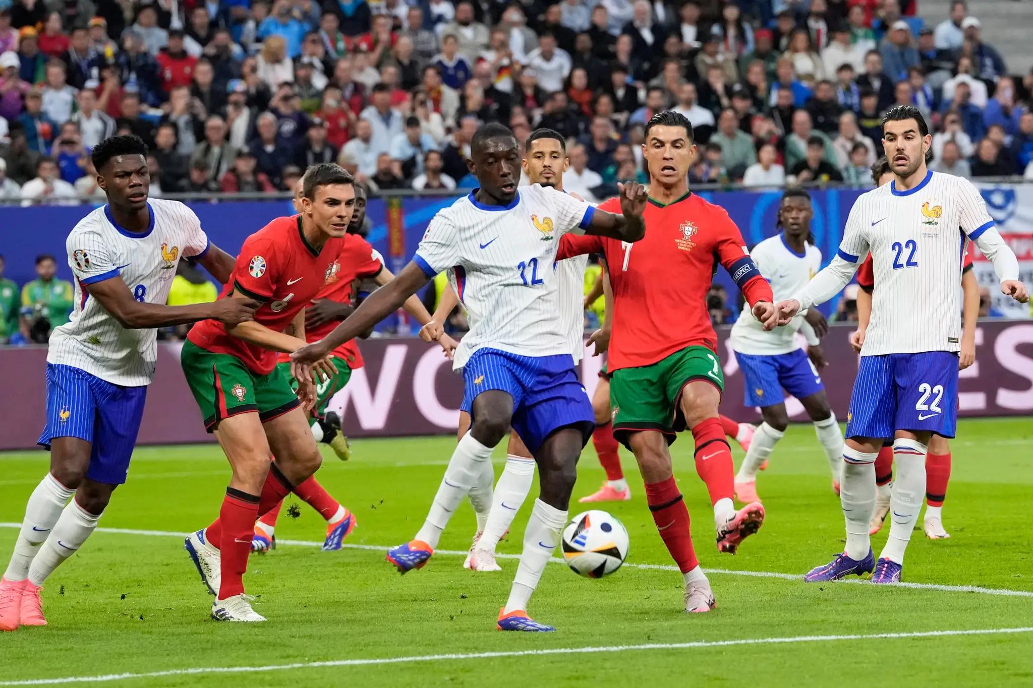 Portugalský hráč Cristiano Ronaldo (uprostred vpravo) bojuje o loptu s Francúzom Randalom Kolom Muanim.