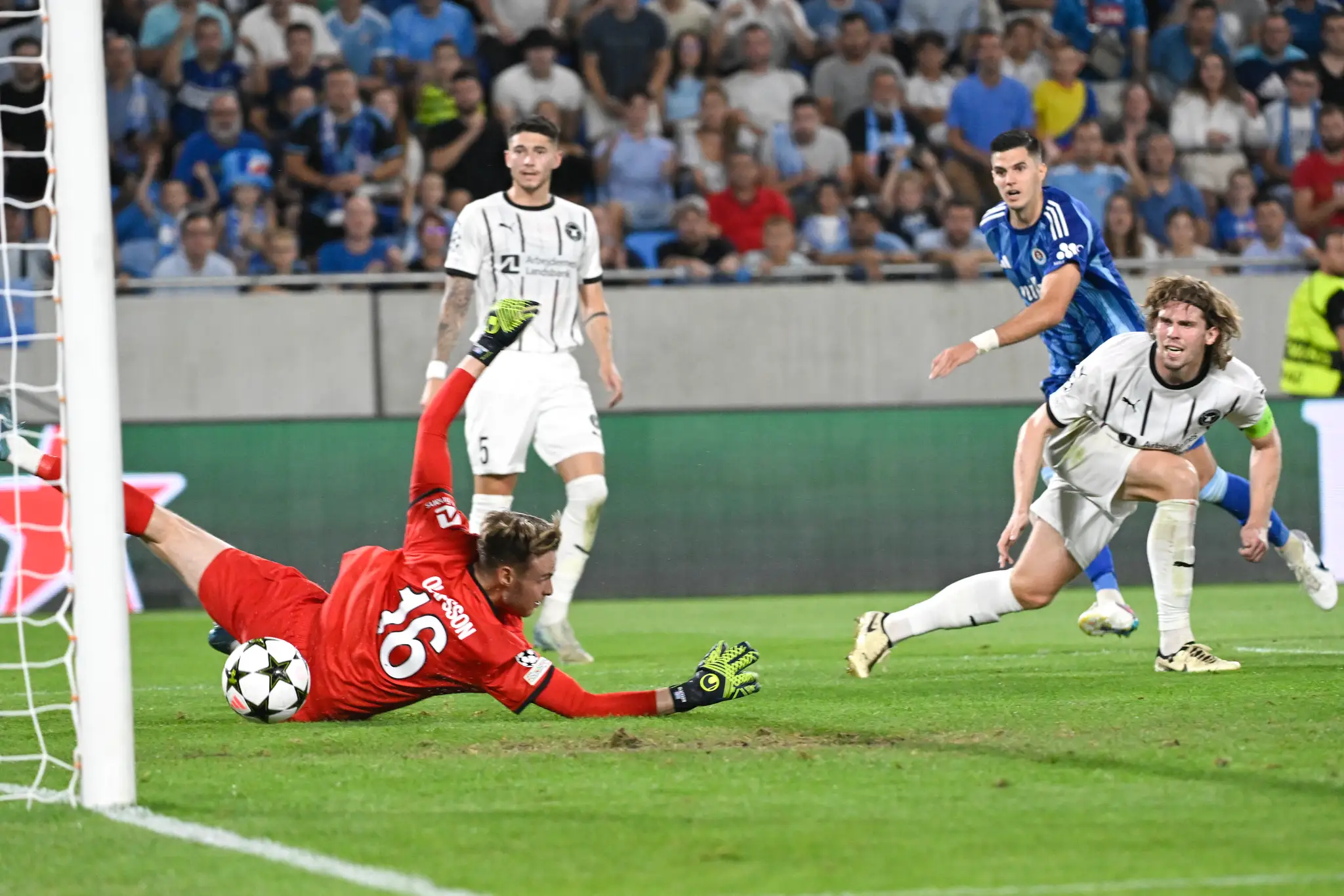 Na snímke v pozadí druhý sprava Marko Tolič (Slovan) strieľa gól brankárovi Eliasovi Rafnovi Ólafssonovi (vpravo Midtjylland).