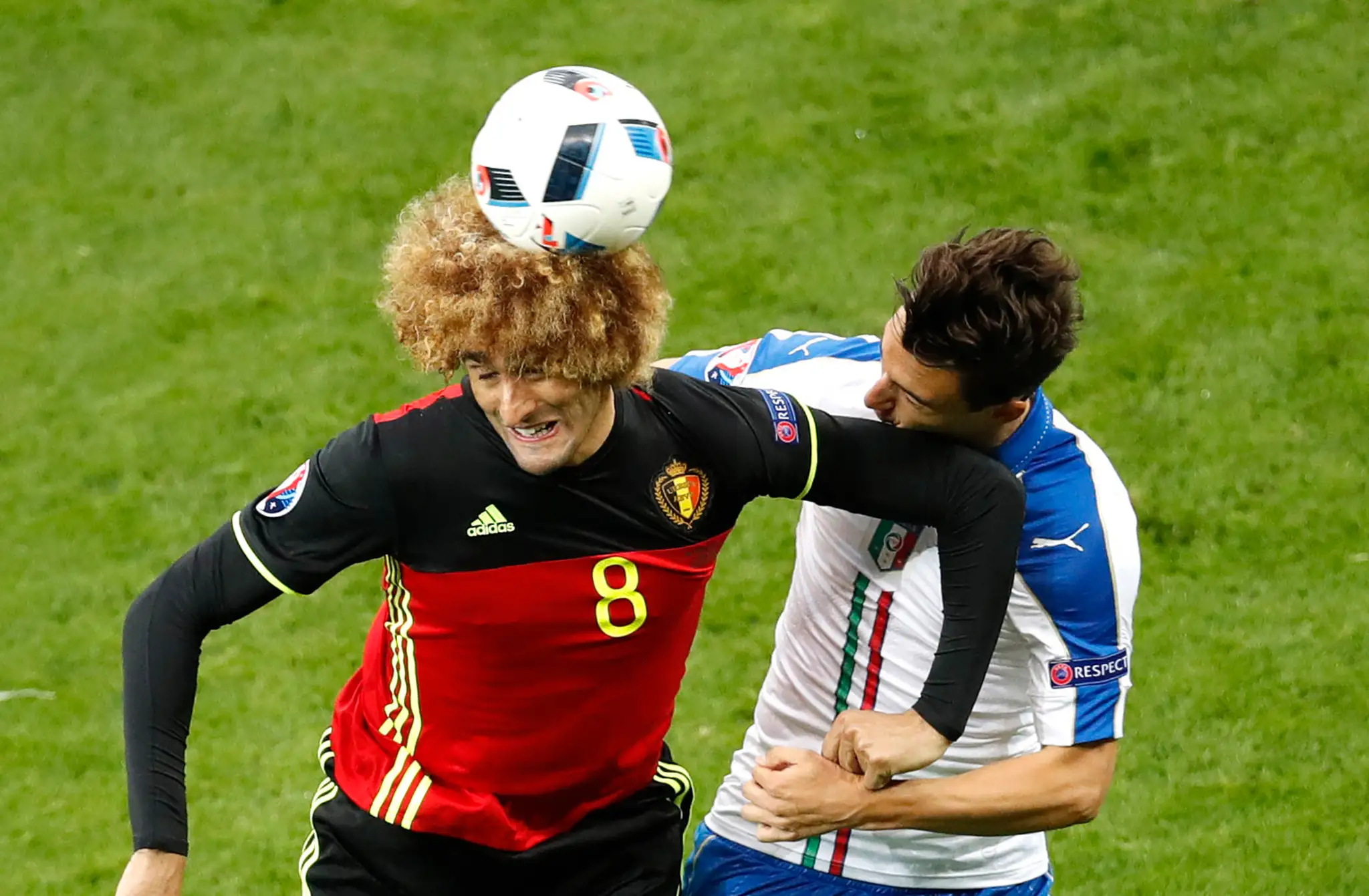 Belgičan Marouane Fellaini (vľavo) a Talian Matteo Darmian vo vzdušnom súboji o loptu na ME vo Francúzsku.