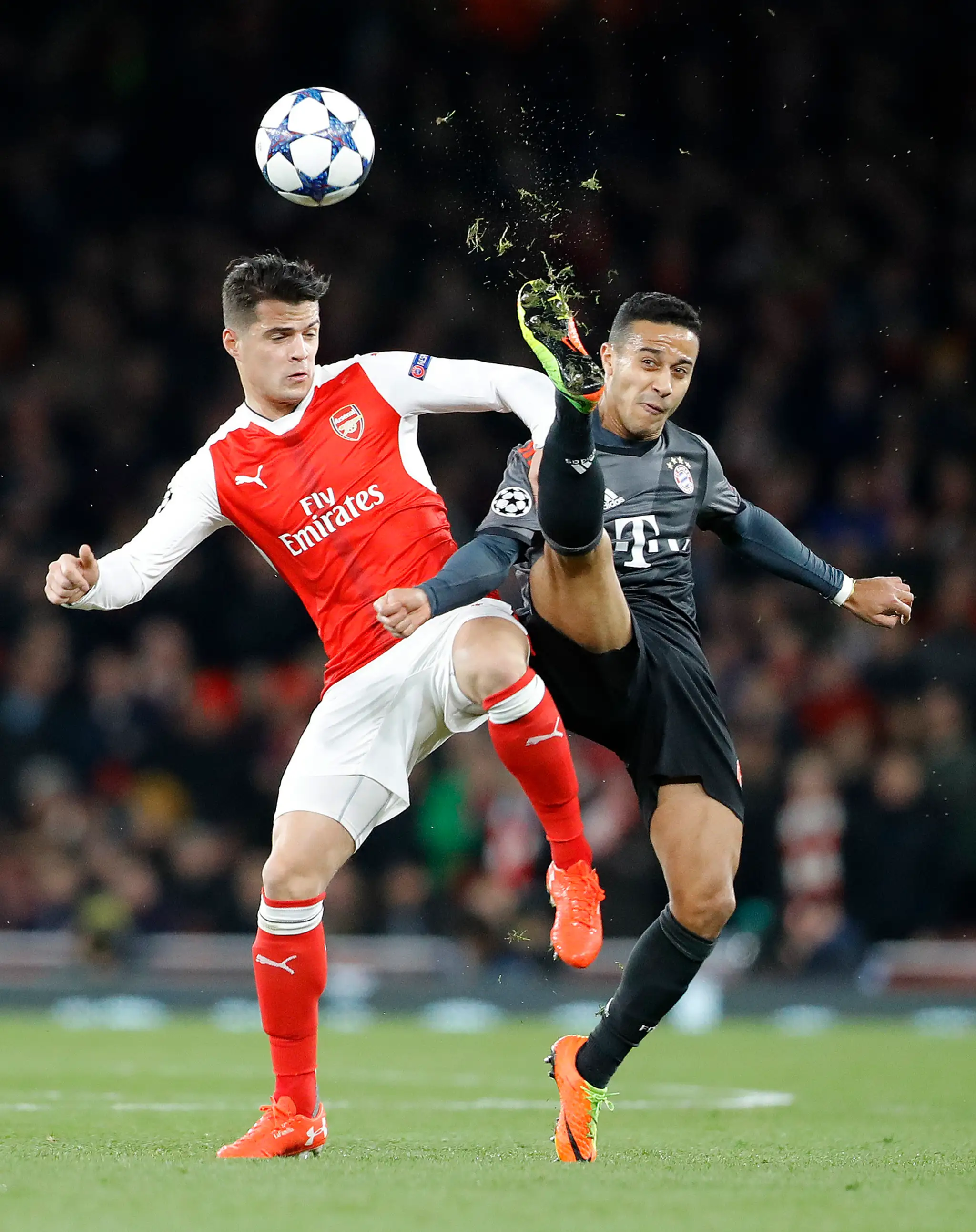 Granit Xhaka (vľavo) z Arsenalu bojuje o loptu s Thiagom Alcántarom z Bayernu v osemfinále LM..