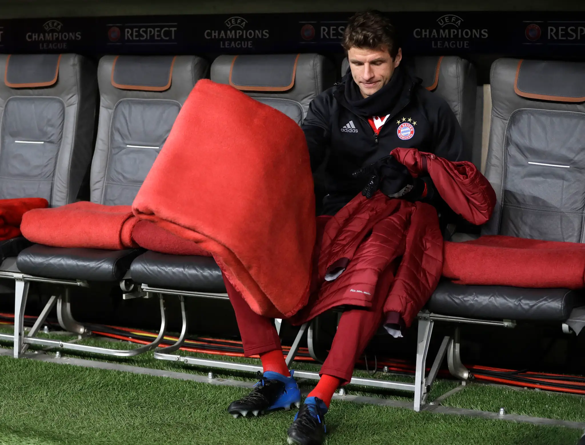 Thomas Müller z Bayernu sedí na lavičke náhradníkov v zápase osemfinále LM proti Arsenalu.
