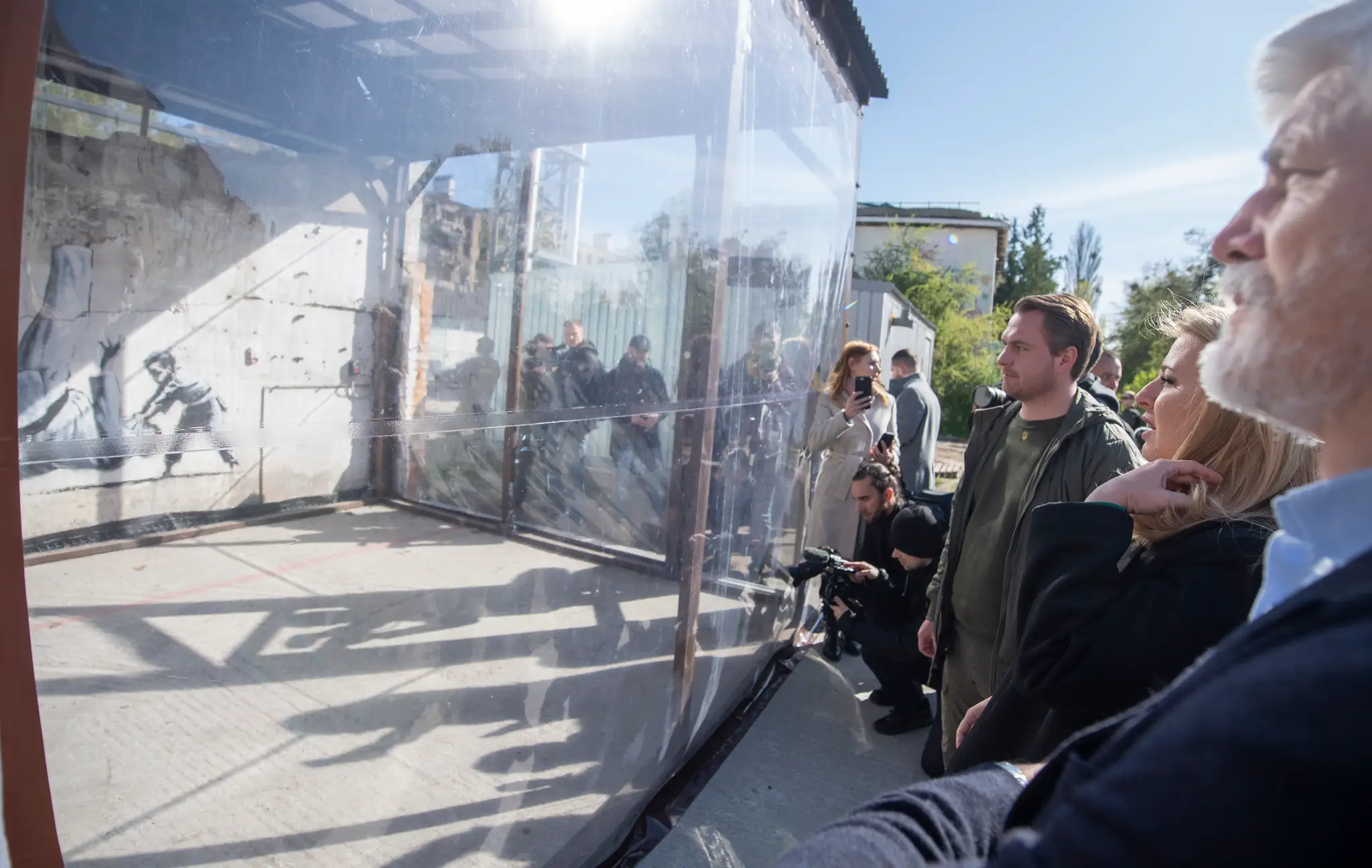 Prezidentka SR Zuzana Čaputová (druhá sprava) a český prezident Petr Pavel (vpravo) si prezerajú dielo britského streetartového umelca Banksyho zobrazujúce dieťa, ktoré v zápase v džude vyhráva nad ruským prezidentom Vladimirom Putinom.