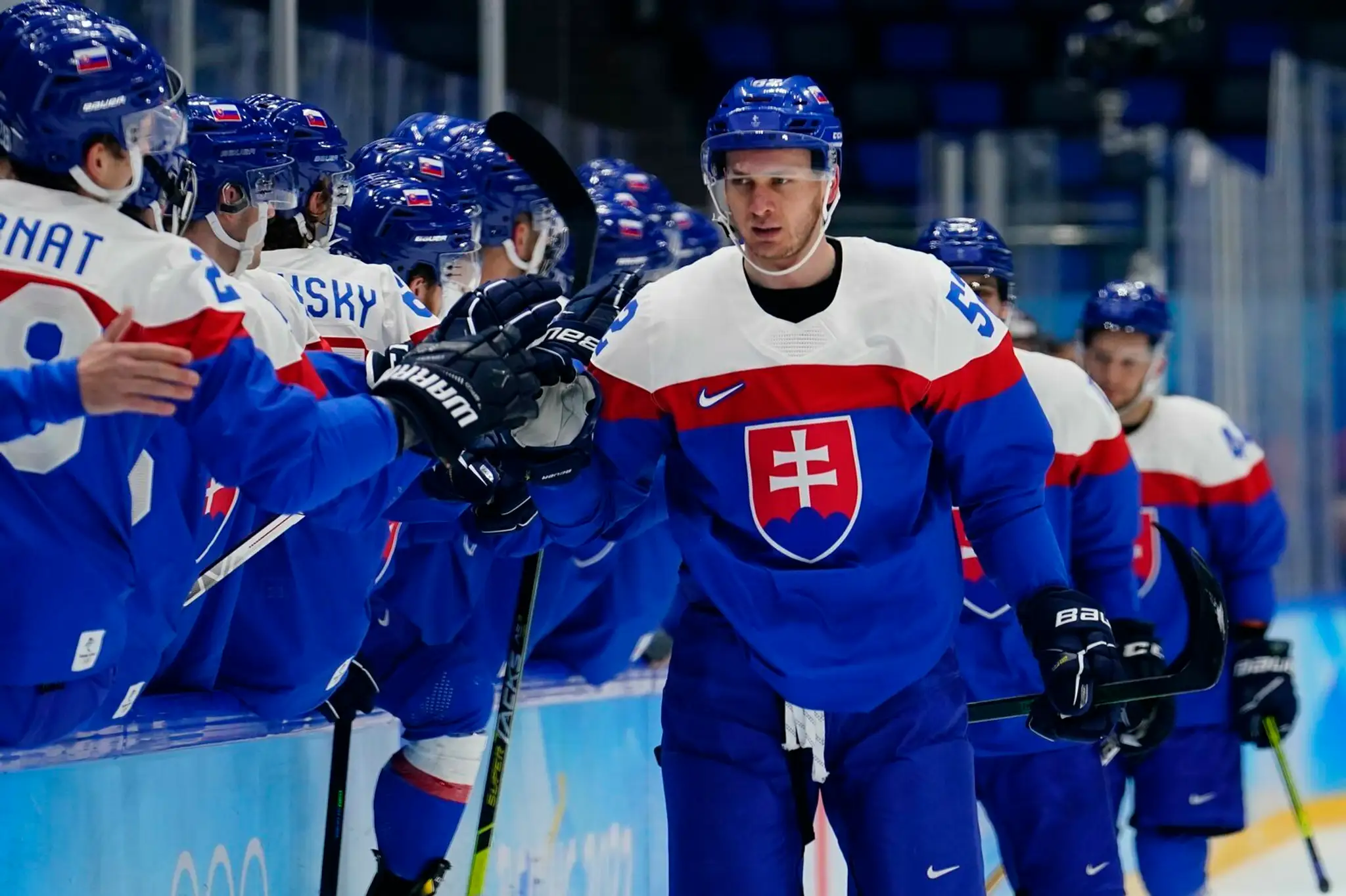 Martin Marinčin oslavuje so spoluhráčmi zo slovenskej reprezentácie gól na ZOH 2022 proti Lotyšsku.