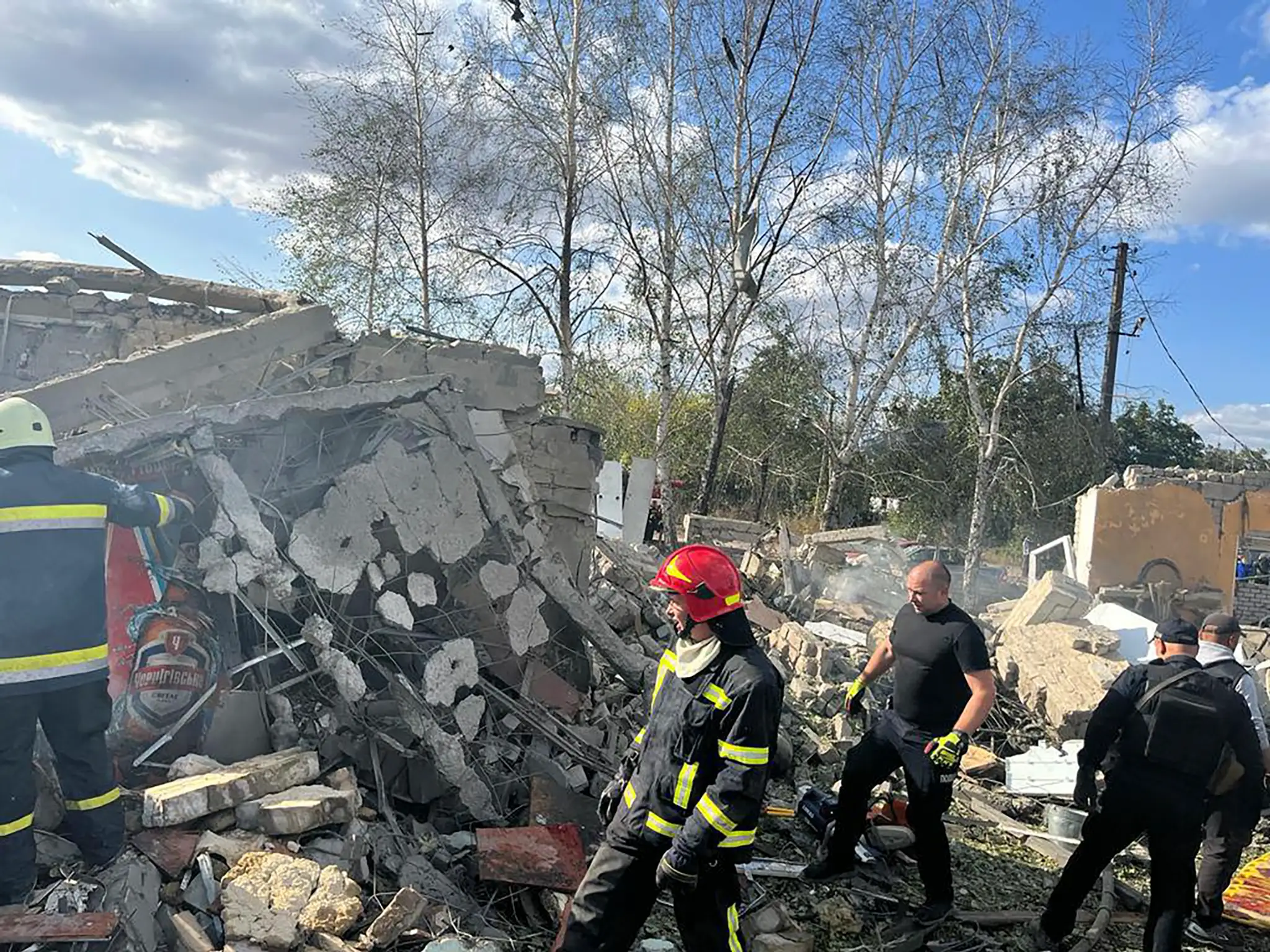 Na snímke hasiči hľadajú obete po ruskom raketovom útoku na dedinu Hroza