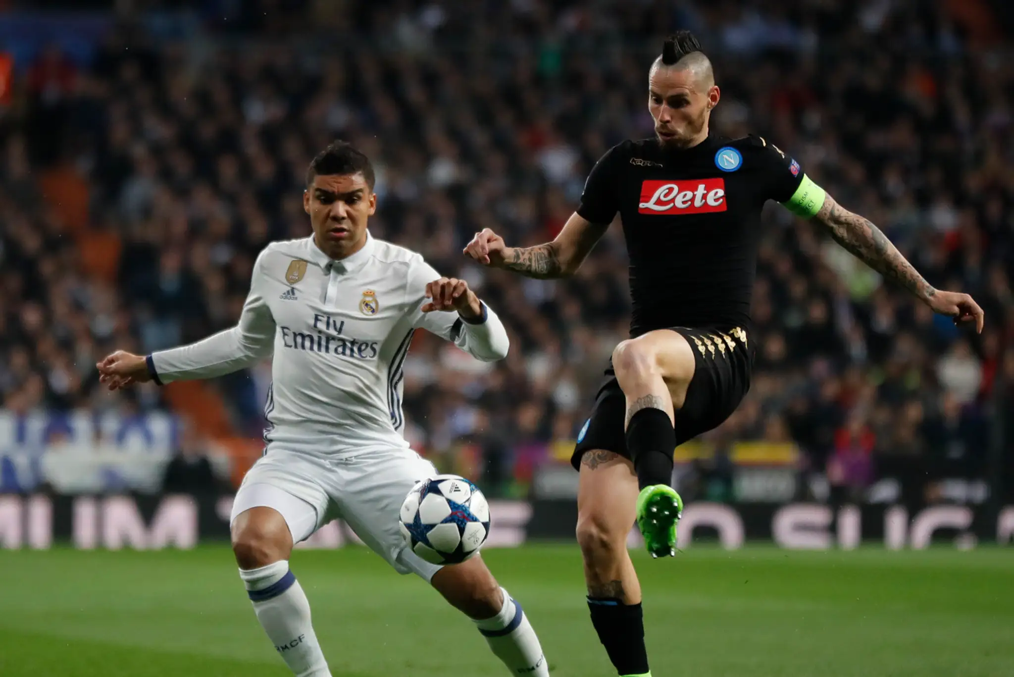 Kapitán Neapola Marek Hamšík (vpravo) bojuje o loptu s Casemirom z Realu v osemfinále LM.