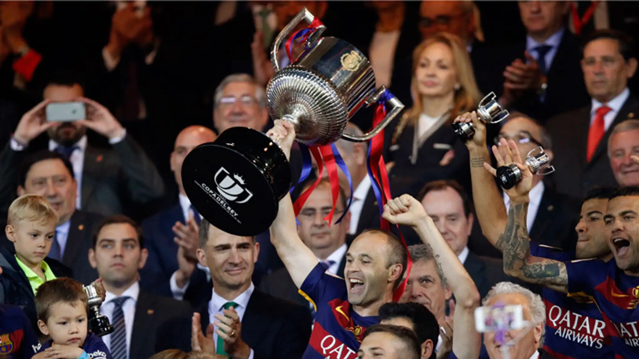 Futbalista FC Barcelona Andres Iniesta dvíha nad hlavu trofej po triumfe vo finále španielskeho pohára Copa del Rey proti FC Sev