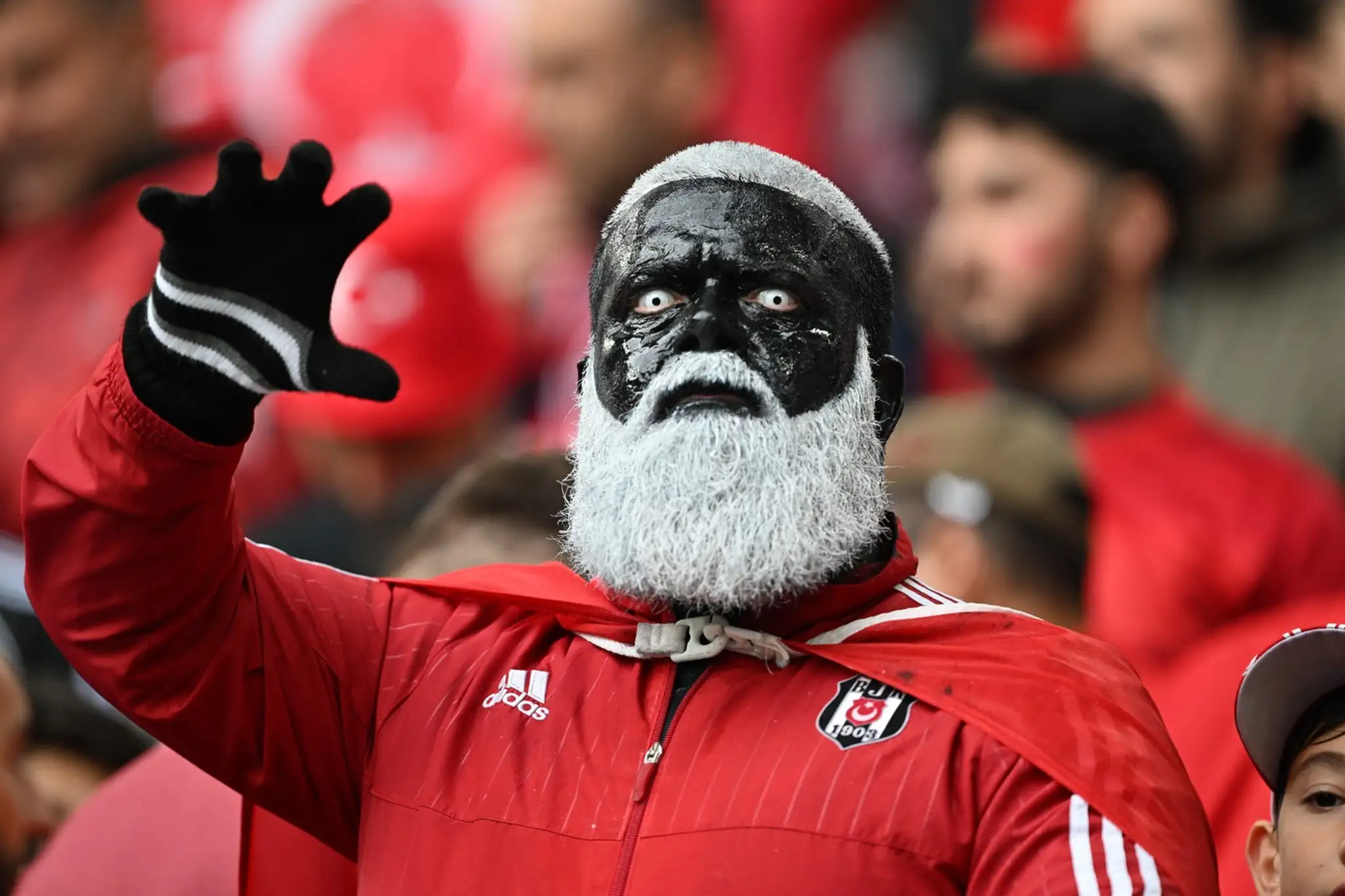 Fanúšik Turecka vo farbách Besiktasa Istanbul.