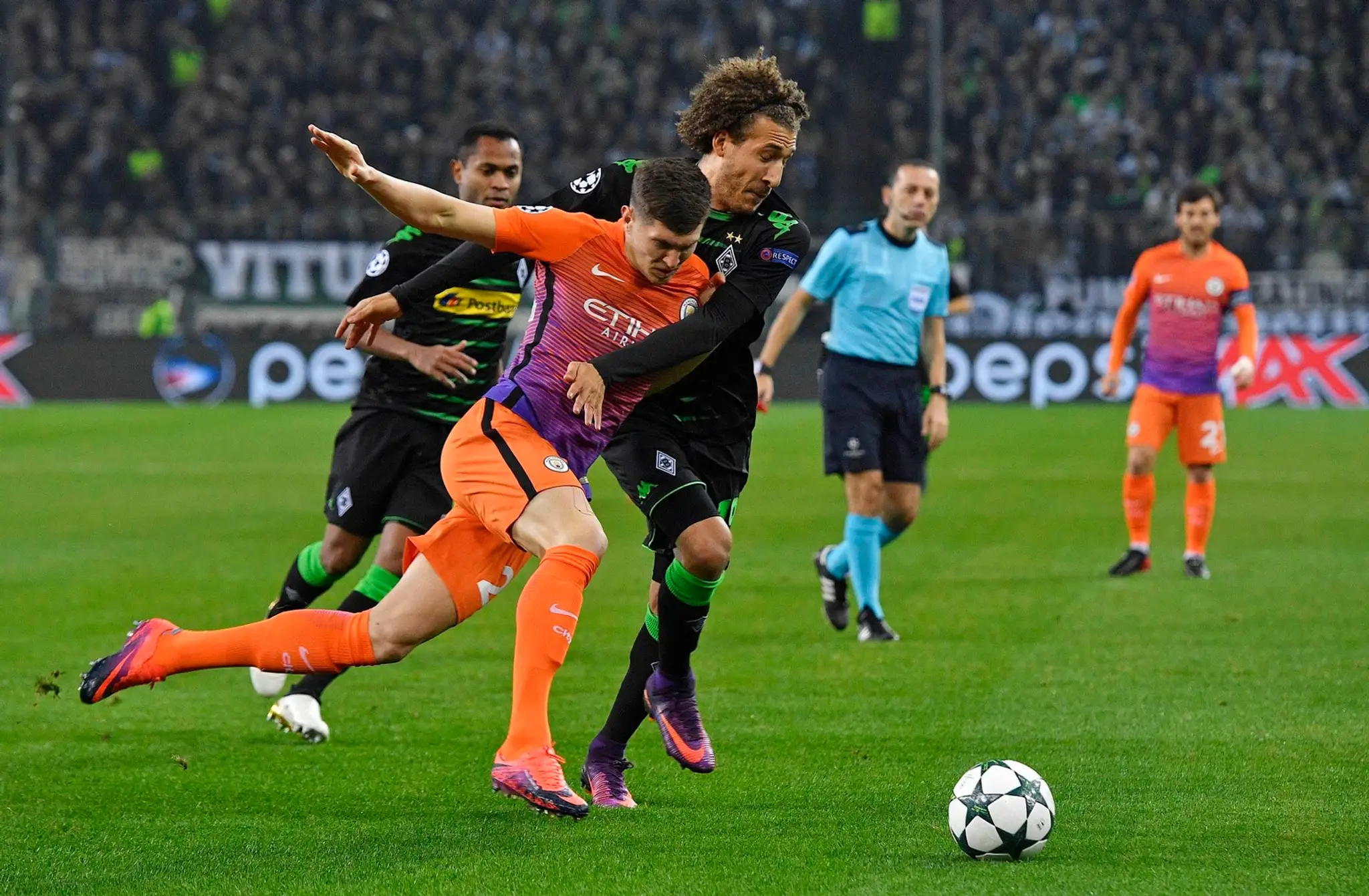 Beka Manchestru City Johna Stonesa (v oranžovom) sa v dueli LM snaži zastaviť Fabian Johnson z Borussie Mönchengladbach.