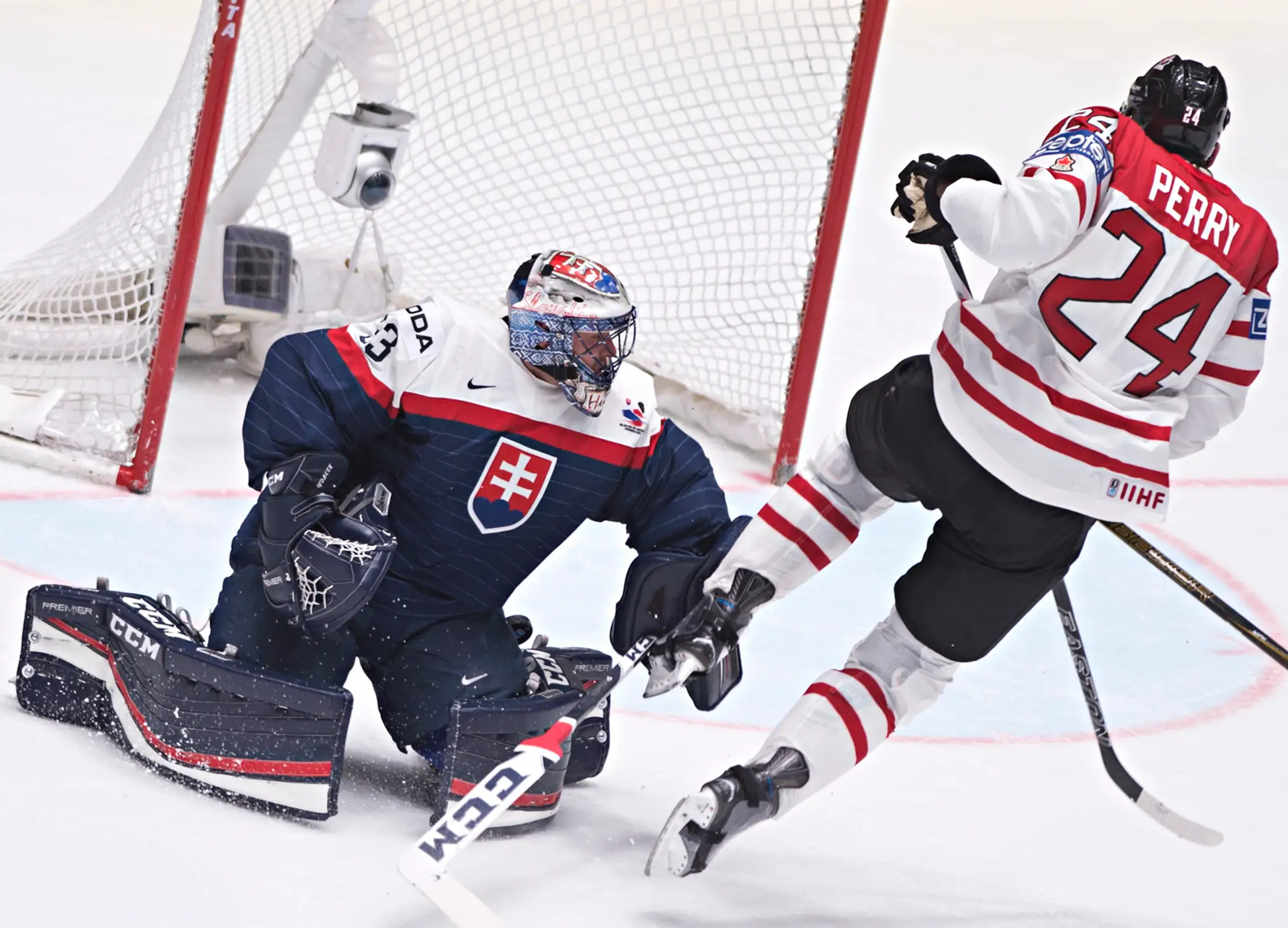 Na snímke vľavo brankár Július Hudáček (Slovensko) a vpravo Corey Perry (Kanada) v zápase B-skupiny hokejových MS v Rusku.