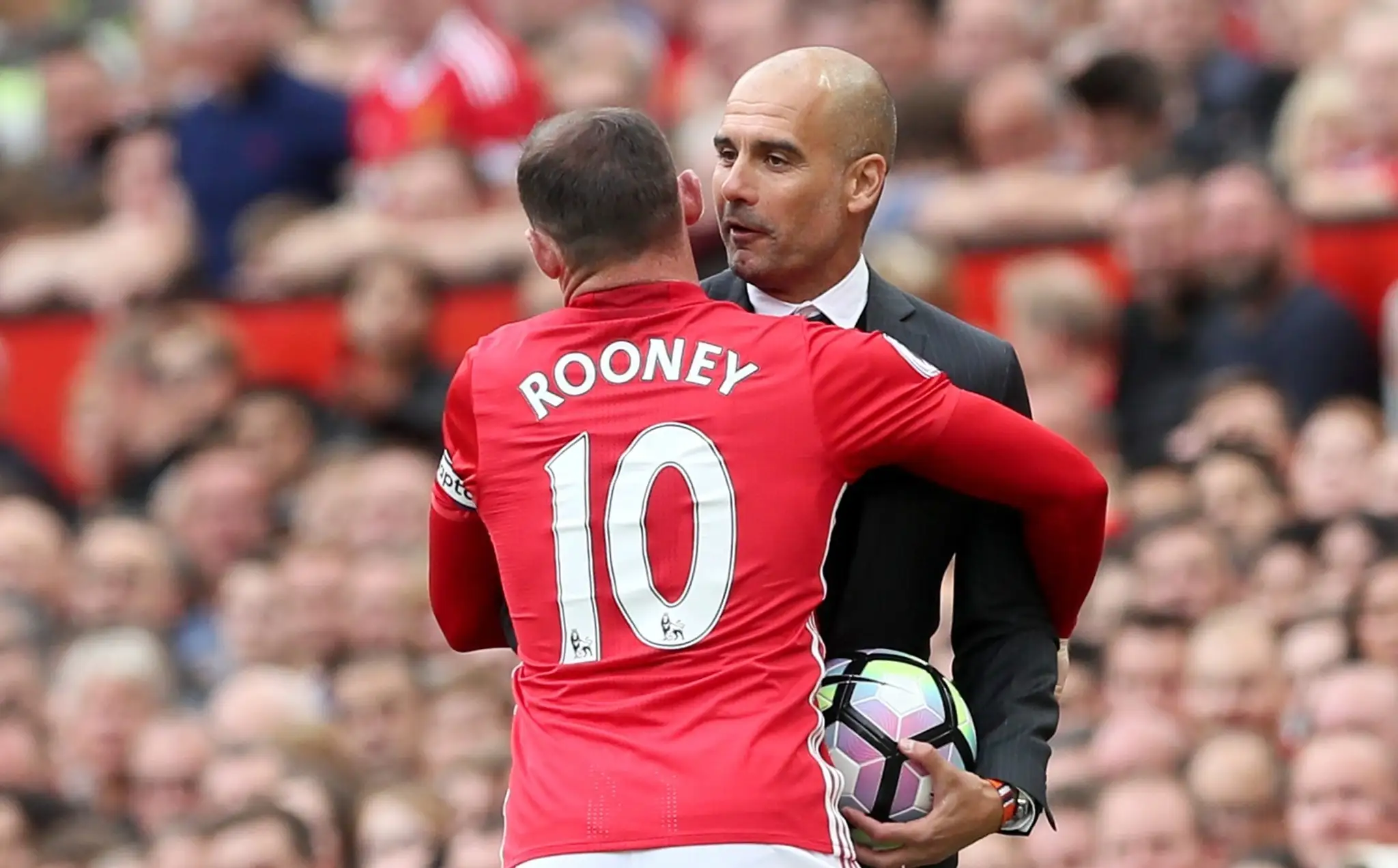 Wayne Rooney v súboji o loptu s Pepom Guardiolom.
