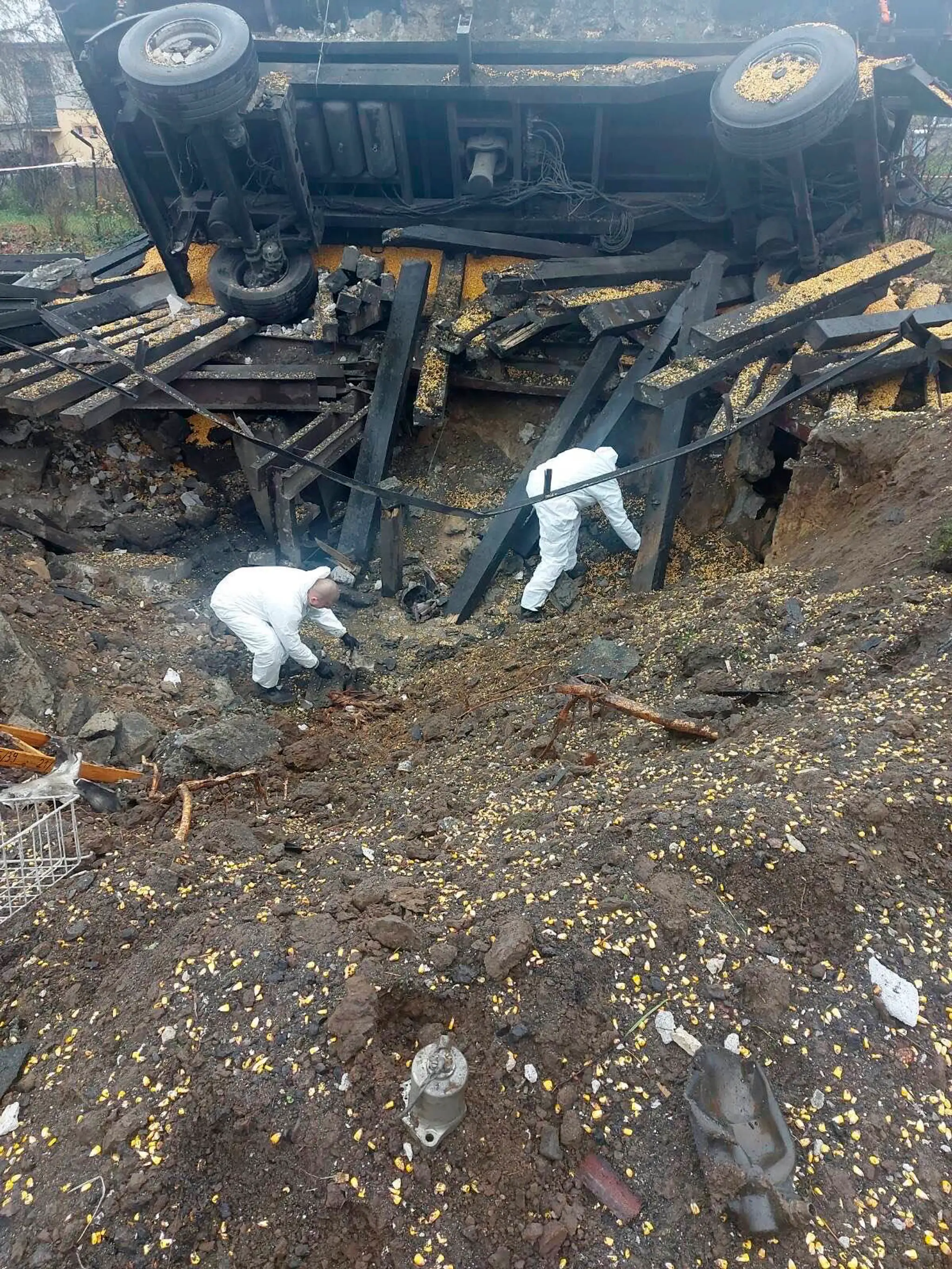 Na policajnej snímke experti vyšetrujú na mieste dopadu rakety v poľskej obci Przewodów, ktorá leží len asi šesť kilometrov od ukrajinských hraníc.