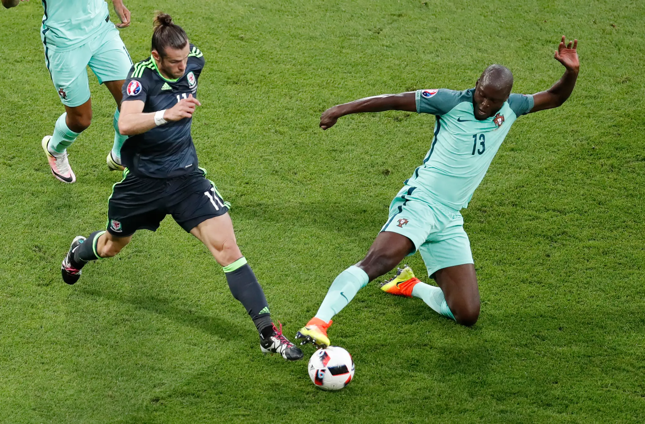 Walesan Gareth Bale v tmavom drese proti Portugalčanovi Danilovi v semifinále ME vo Francúzsku.