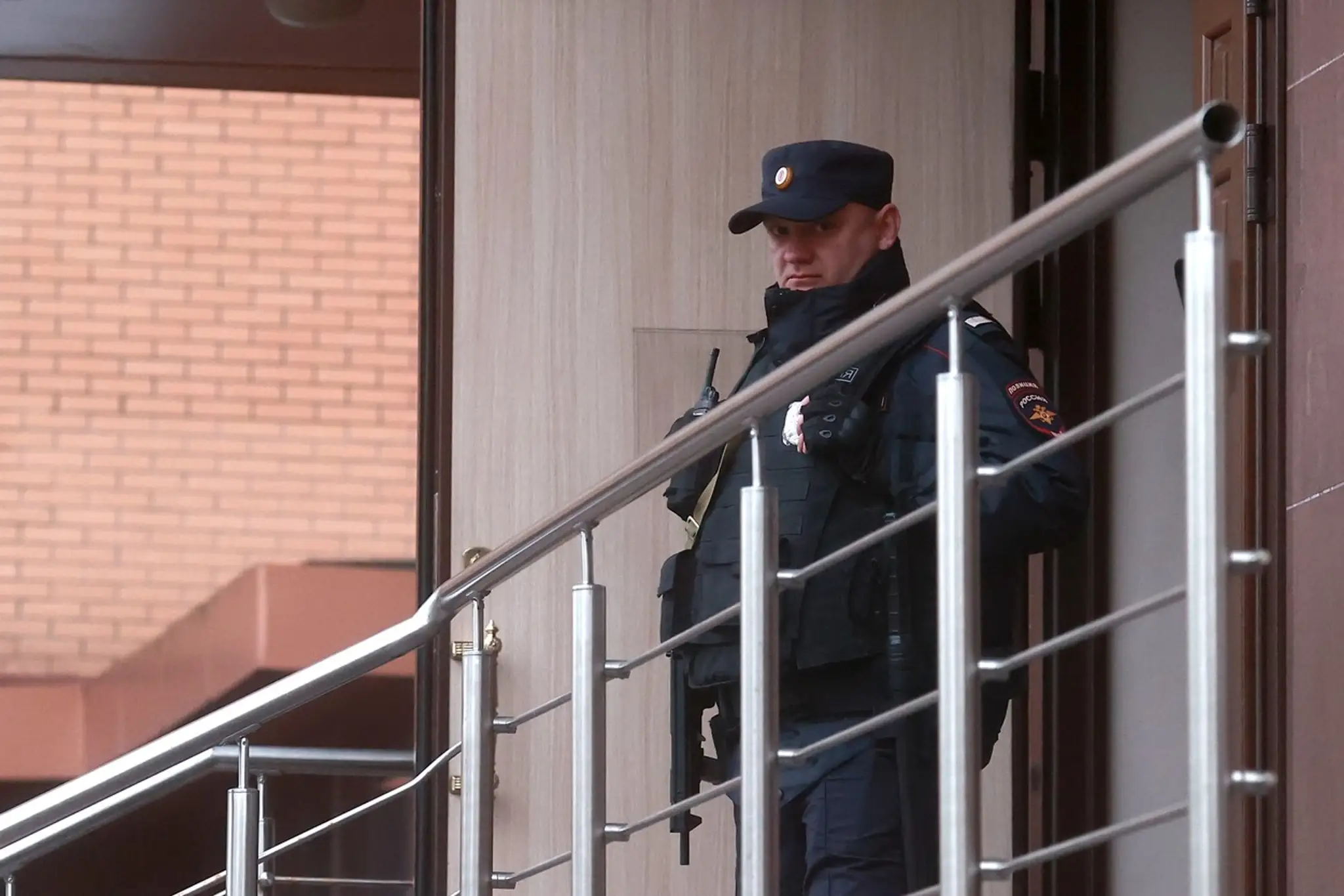 Policajt stojí pred domom, v ktorom našli telá rodiny Avajevovcov.