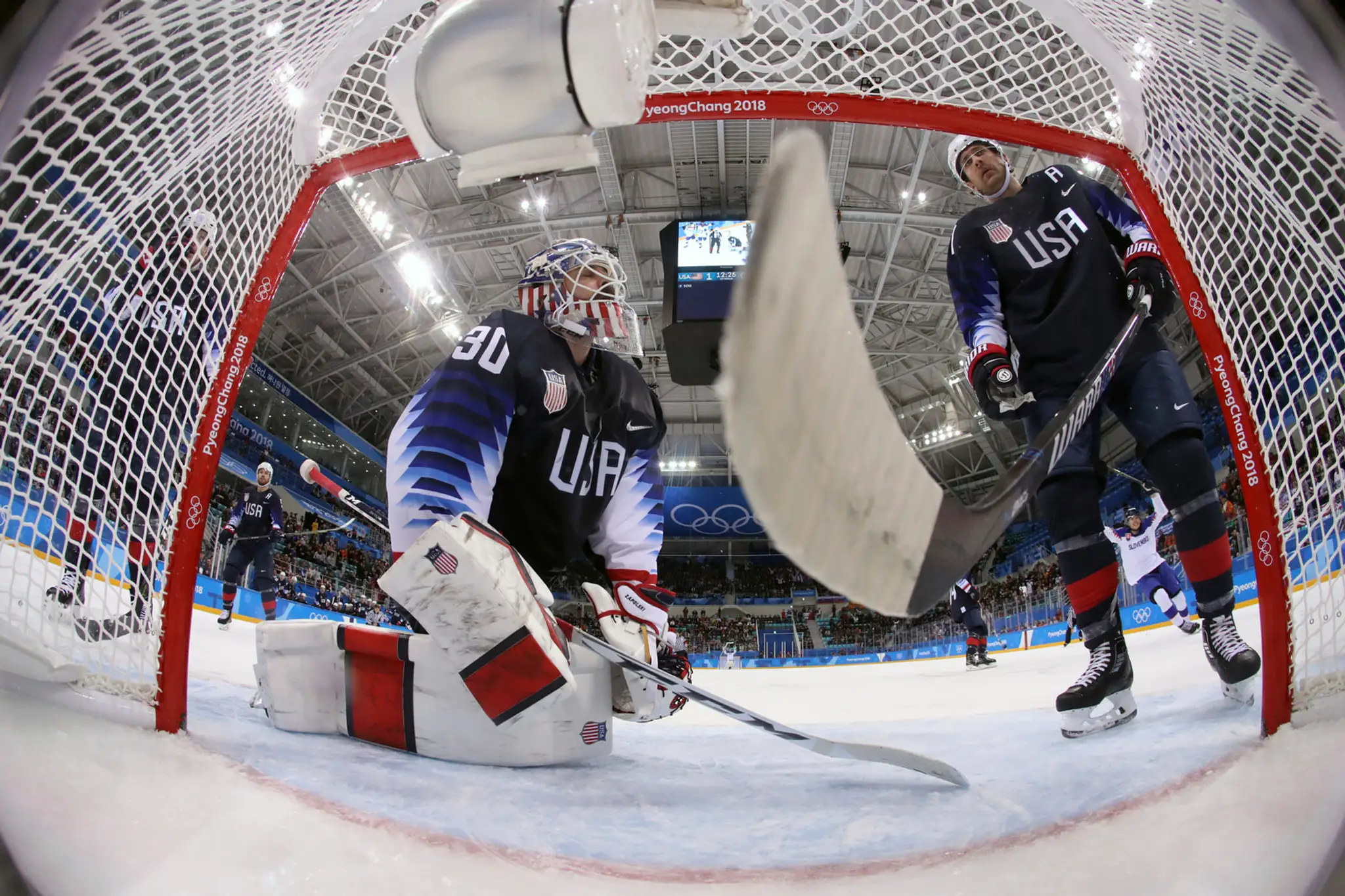 Peter Olvecký (vľavo) bojuje o puk s Troyom Terrym z USA v zápase na ZOH 2018.