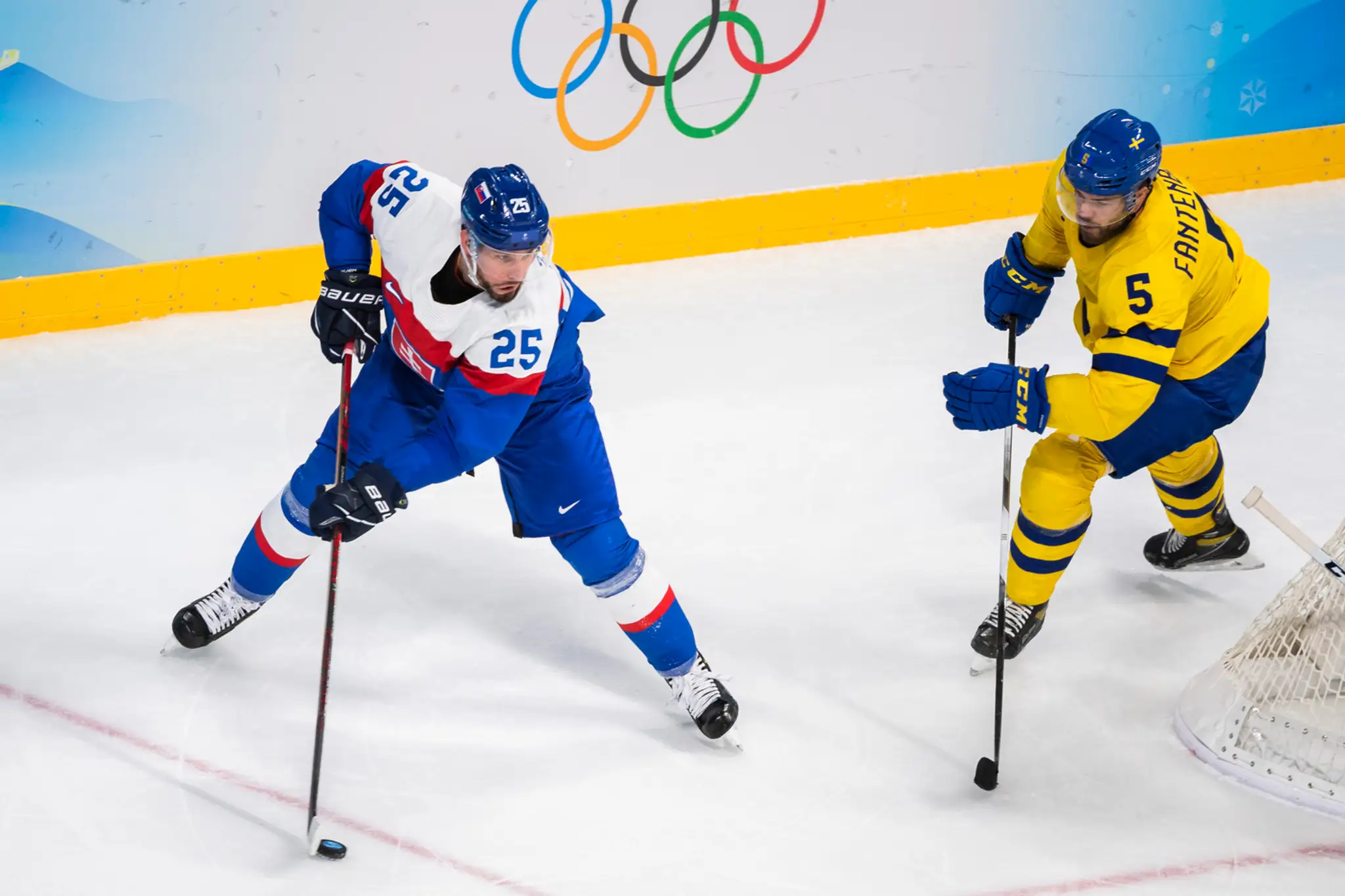 Zľava hokejista Slovenska Peter Zuzin a Švéd Oscar Fanterberg v zápase ZOH 2022.