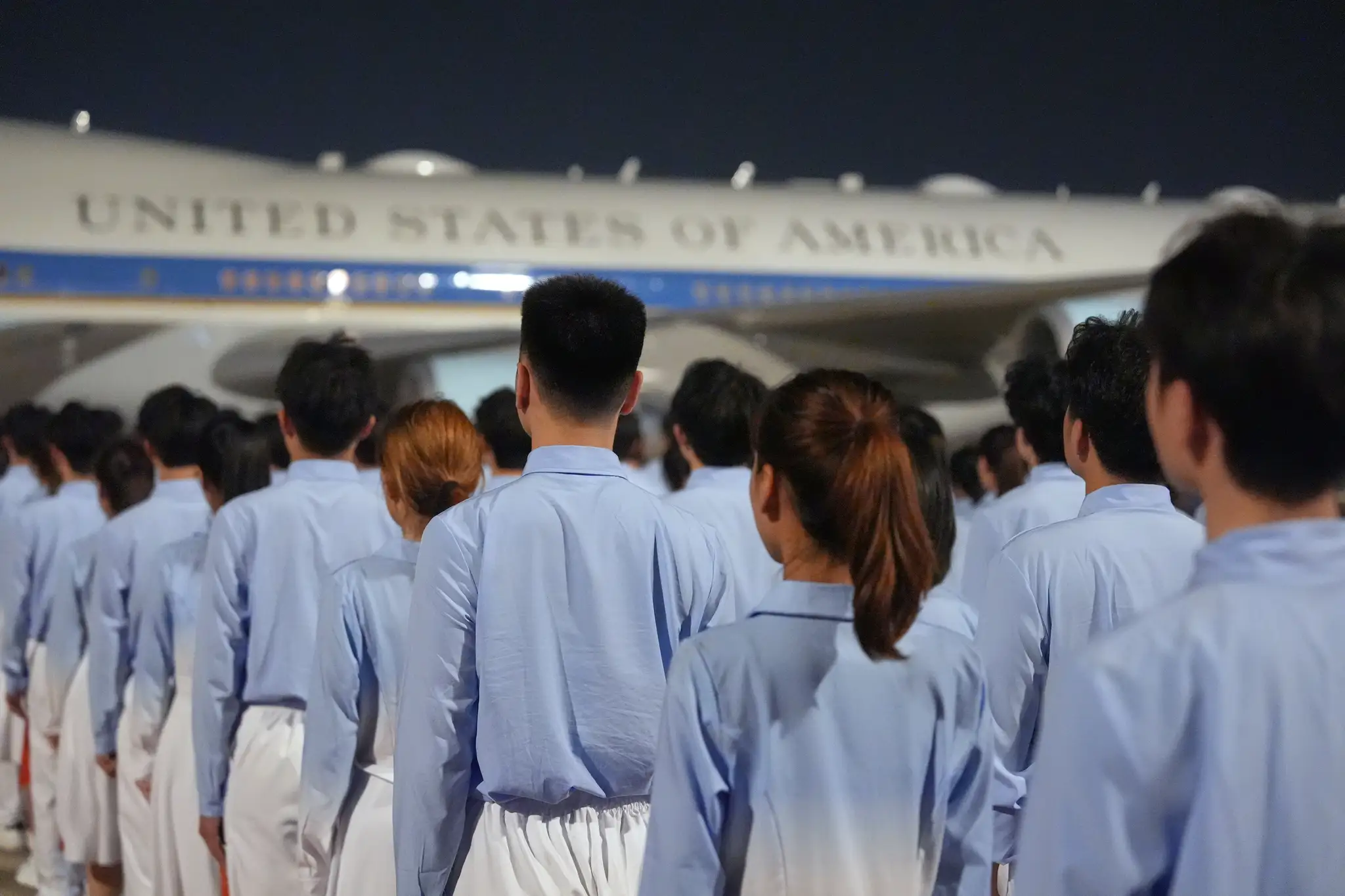 Ľudia čakajú na príchod amerického prezidenta Donalda Trumpa počas uvítacieho ceremoniálu na letisku v Pekingu.