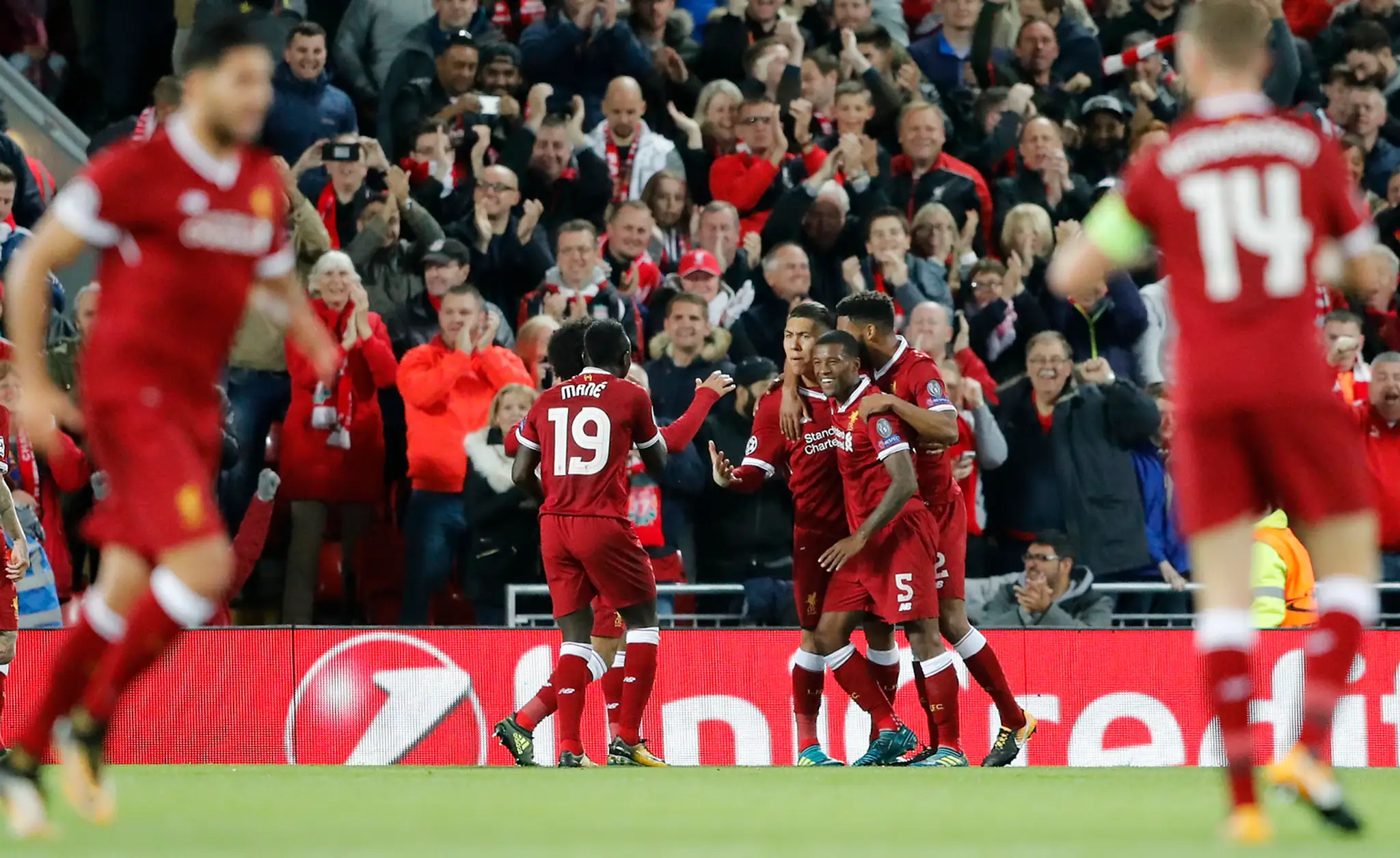 Hráči Liverpoolu oslavujú gól v 1. kole LM proti Seville, strelcom je Roberto Firmino.