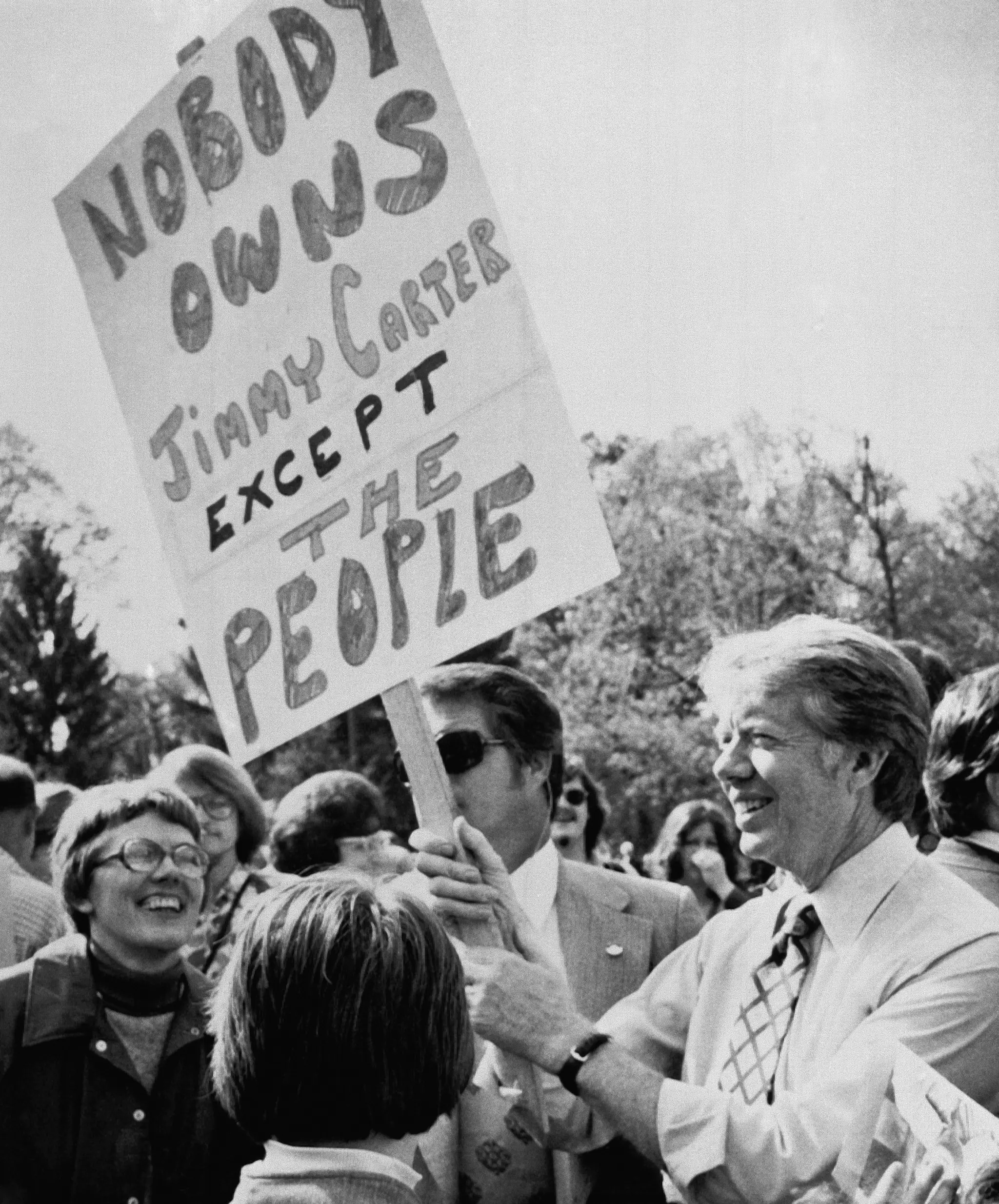 Demokratický prezidentský kandidát, bývalý guvernér Georgie Jimmy Carter, vpravo, drží plagát, keď sa mieša s davom počas návštevy kampane vo Williamsporte v Pensylvánii, 24. apríla 1976.