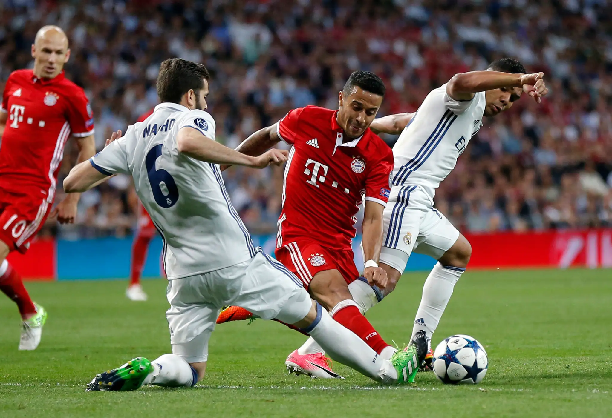 Thiago Alcántara (v strede) z Bayernu súperí o loptu s Nachom (vľavo) a Casemirom z Realu v odvete štvrťfinále LM.