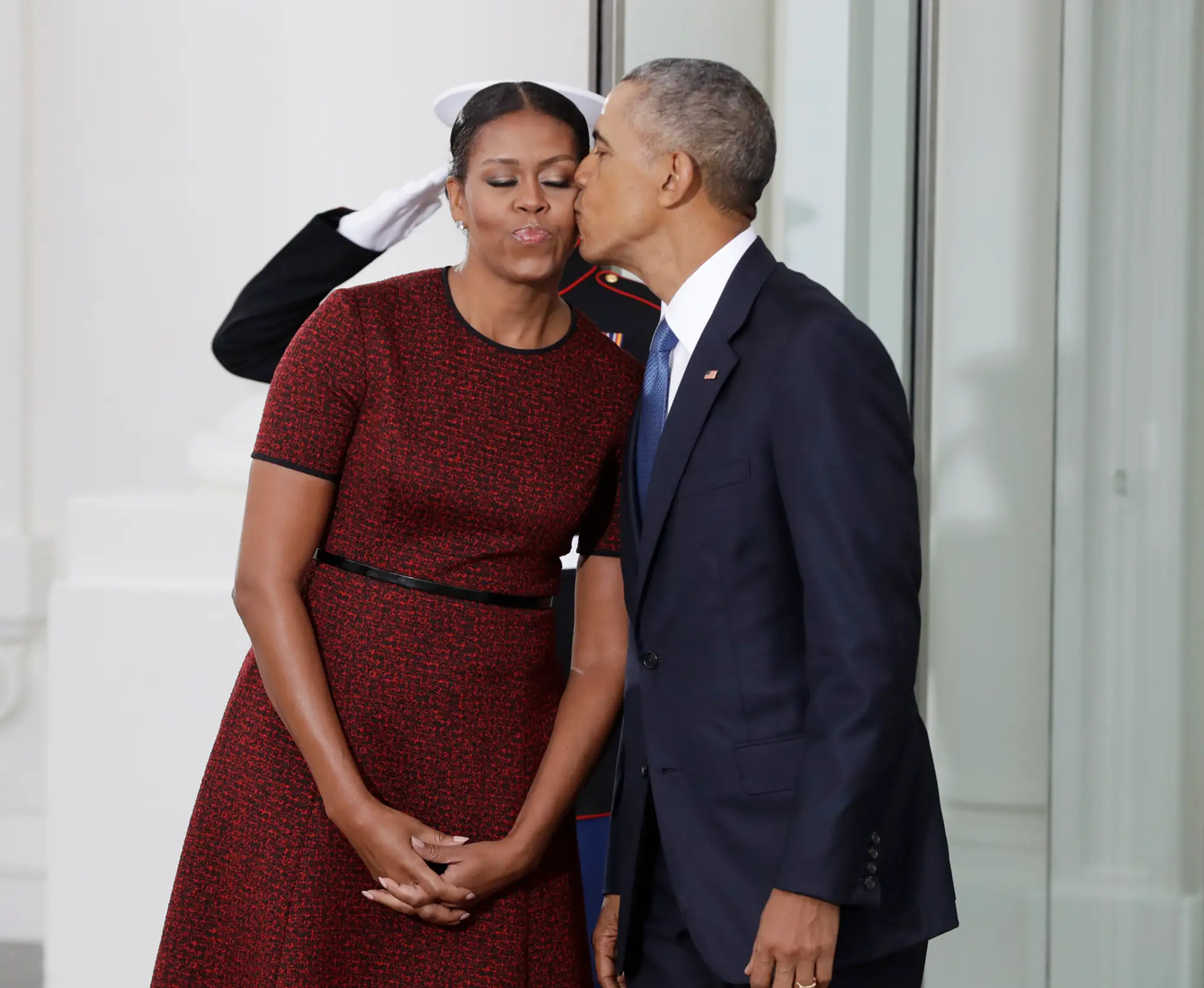 Barack Obama bozkáva svoju manželku Michelle Obamovú počas čakania na príchod Donalda Trumpa v Bielom dome.