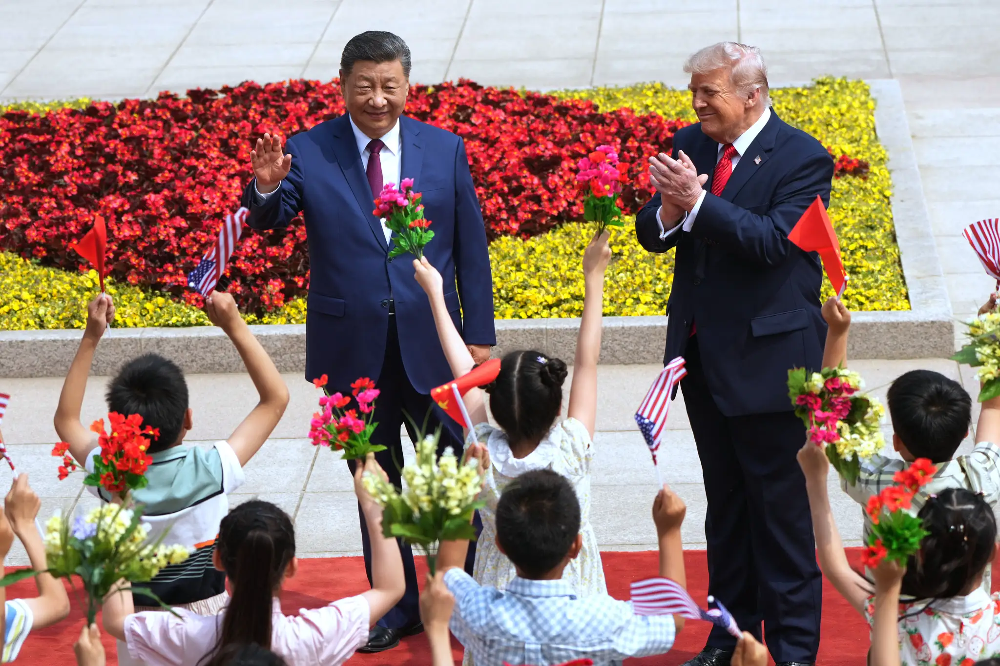 Americký prezident Donald Trump (vpravo) a čínsky prezident Si Ťin-pching sa zdravia s deťmi počas uvítacieho ceremoniálu v Pekingu.