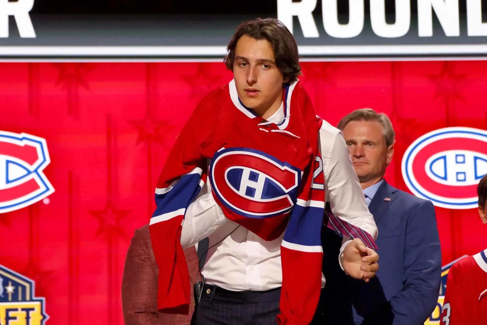 Rakúšan David Reinbacher si oblieka dres Montrealu na NHL drafte.