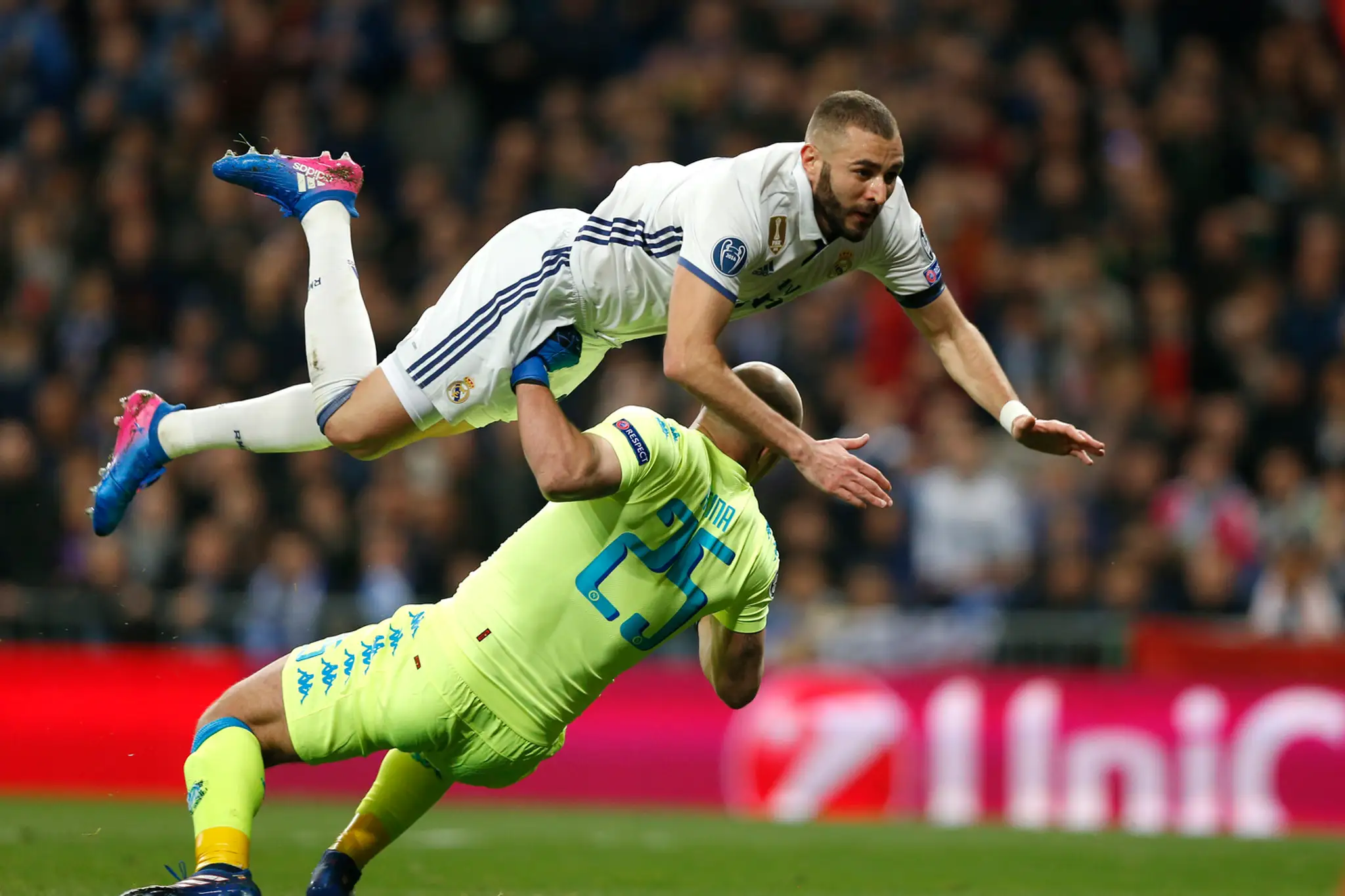 Útočník Realu Karim Benzema padá cez gólmana Neapola Pepeho Reinu v osemfinále LM.