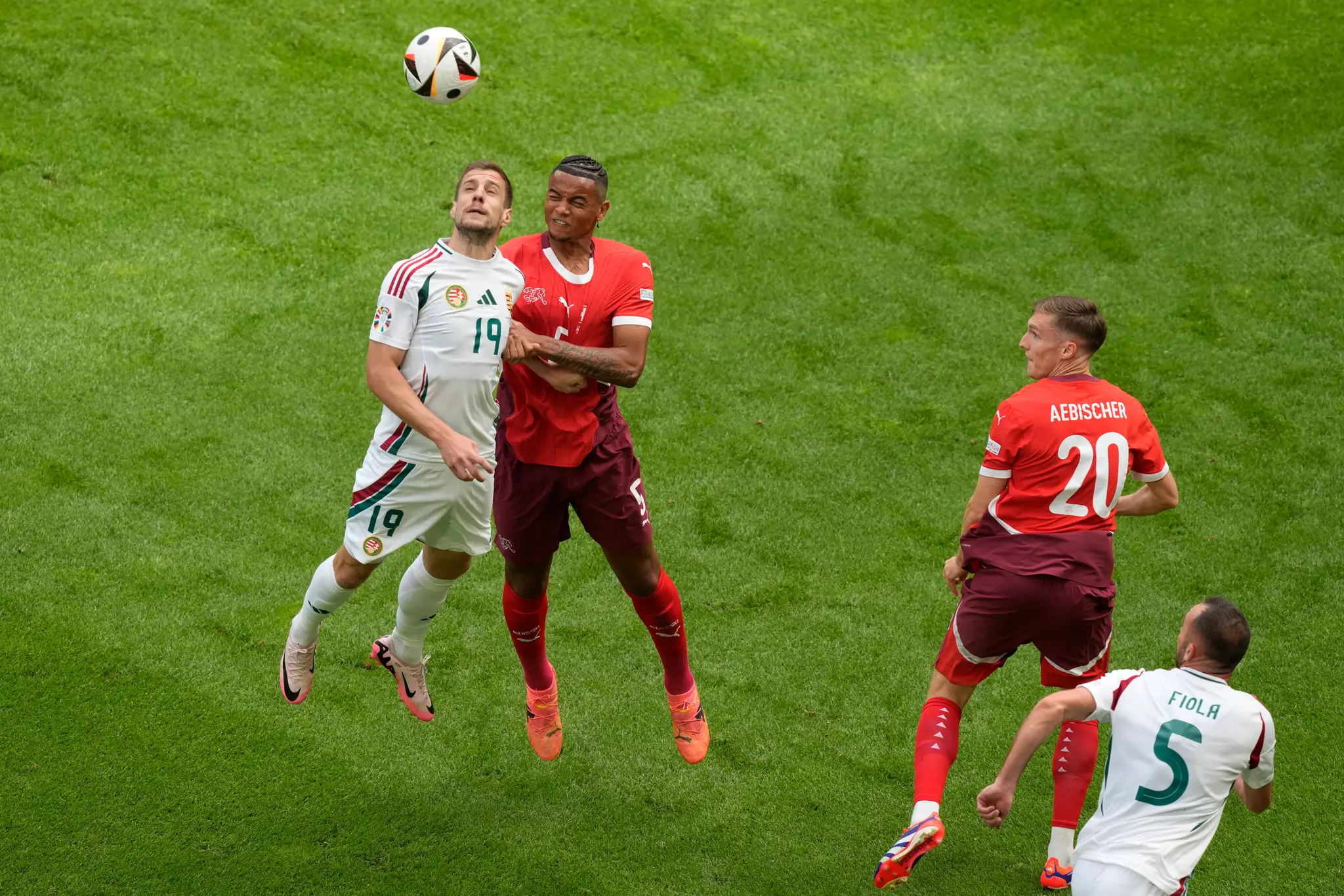 Švajčiarsky hráč Manuel Akanji (uprostred vpravo) v hlavičkovom súboji s Maďarom Barnabasom Vargom (vľavo).