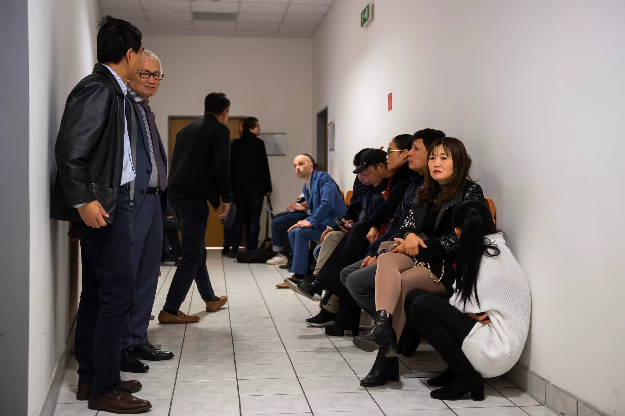 Na snímke ľudia z vietnamskej komunity čakajú na chodbe počas procesu