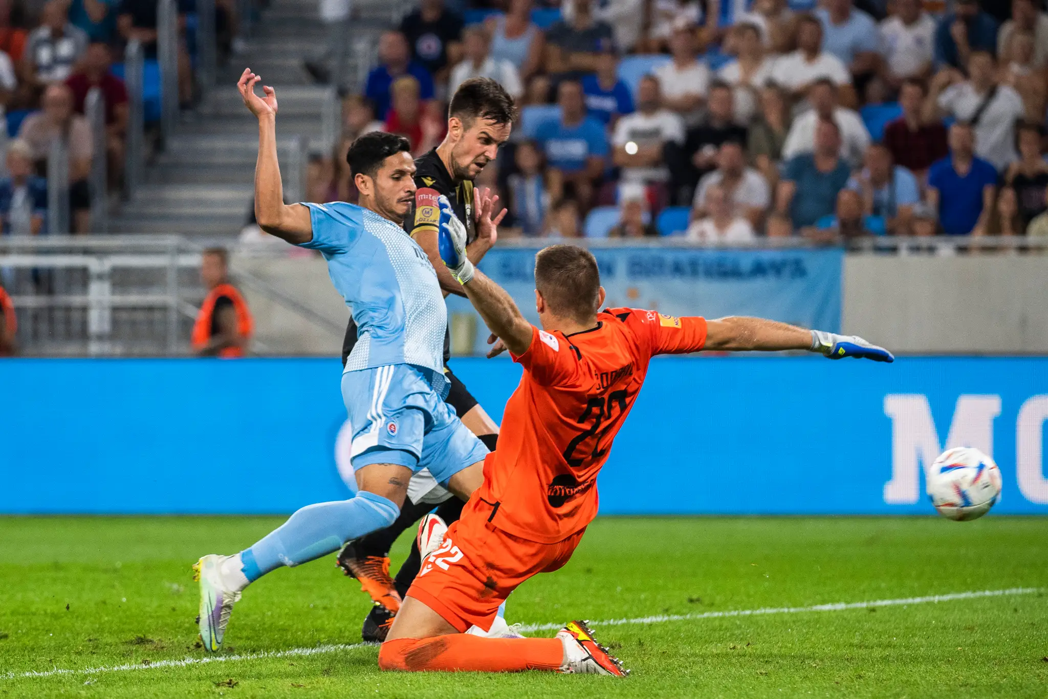 Zľava Eric Ramirez (Slovan) strieľa úvodný gól, v pozadí Hrvoje Barišič a vpravo prekonaný brankár Josip Čondrič (obaja Mostar) v odvete play off Európskej konferenčnej ligy.