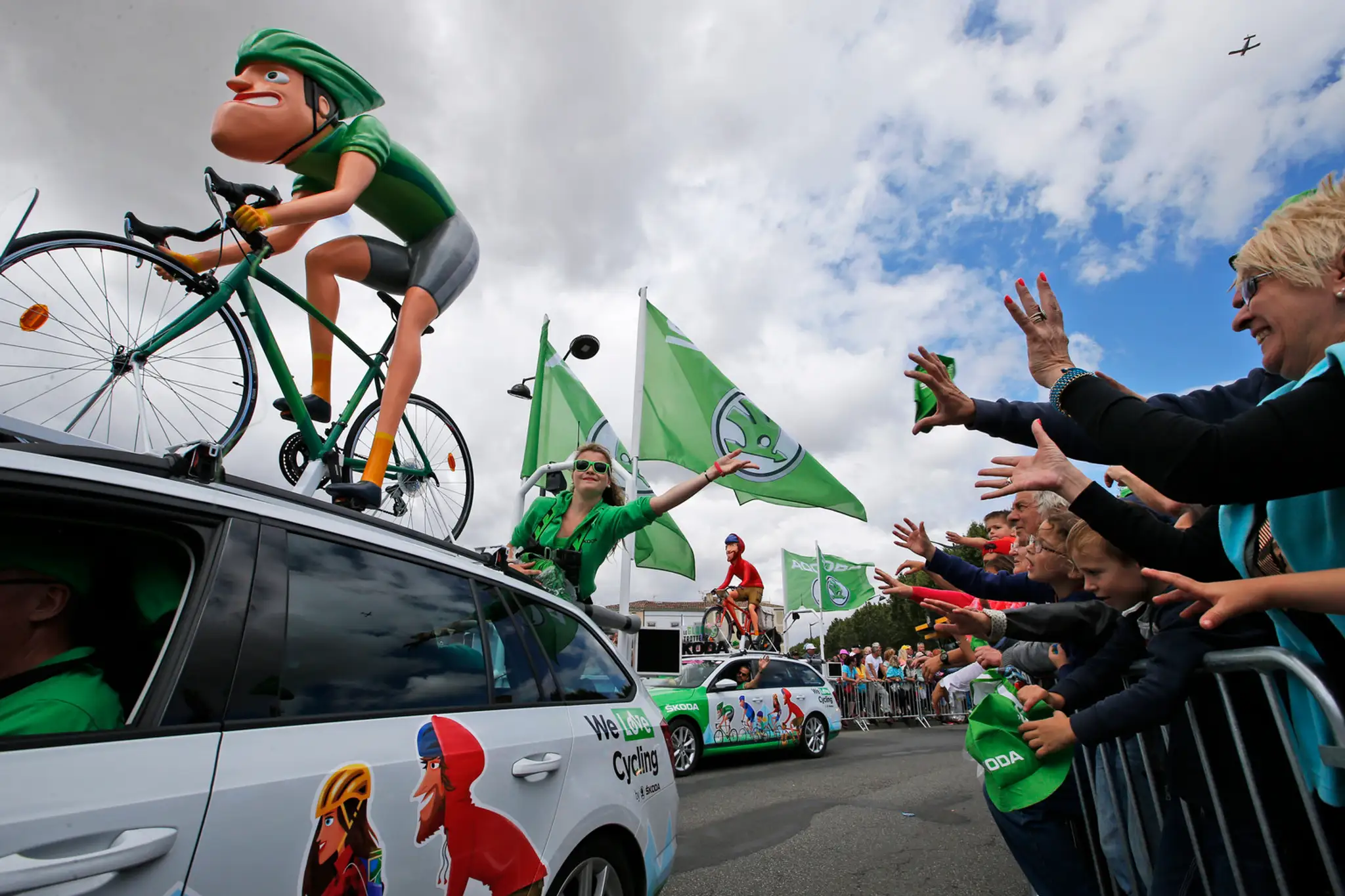 Diváci sa snažia chytiť niektorý z darčekov, ktoré rozhadzovali z áut v rámci prezentácie sponzorov Tour de France