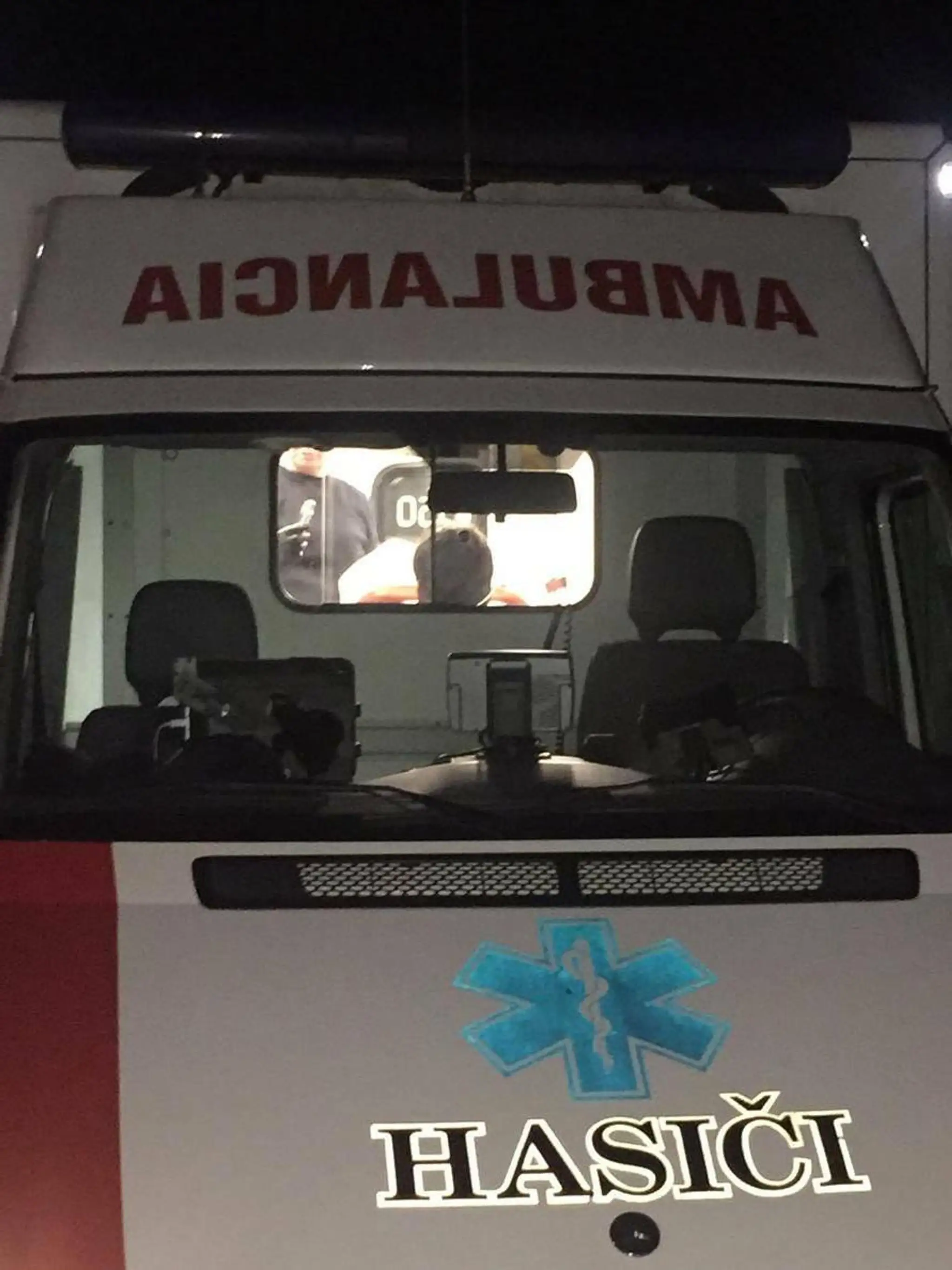 Chlapca ošetrujú v sanitke.