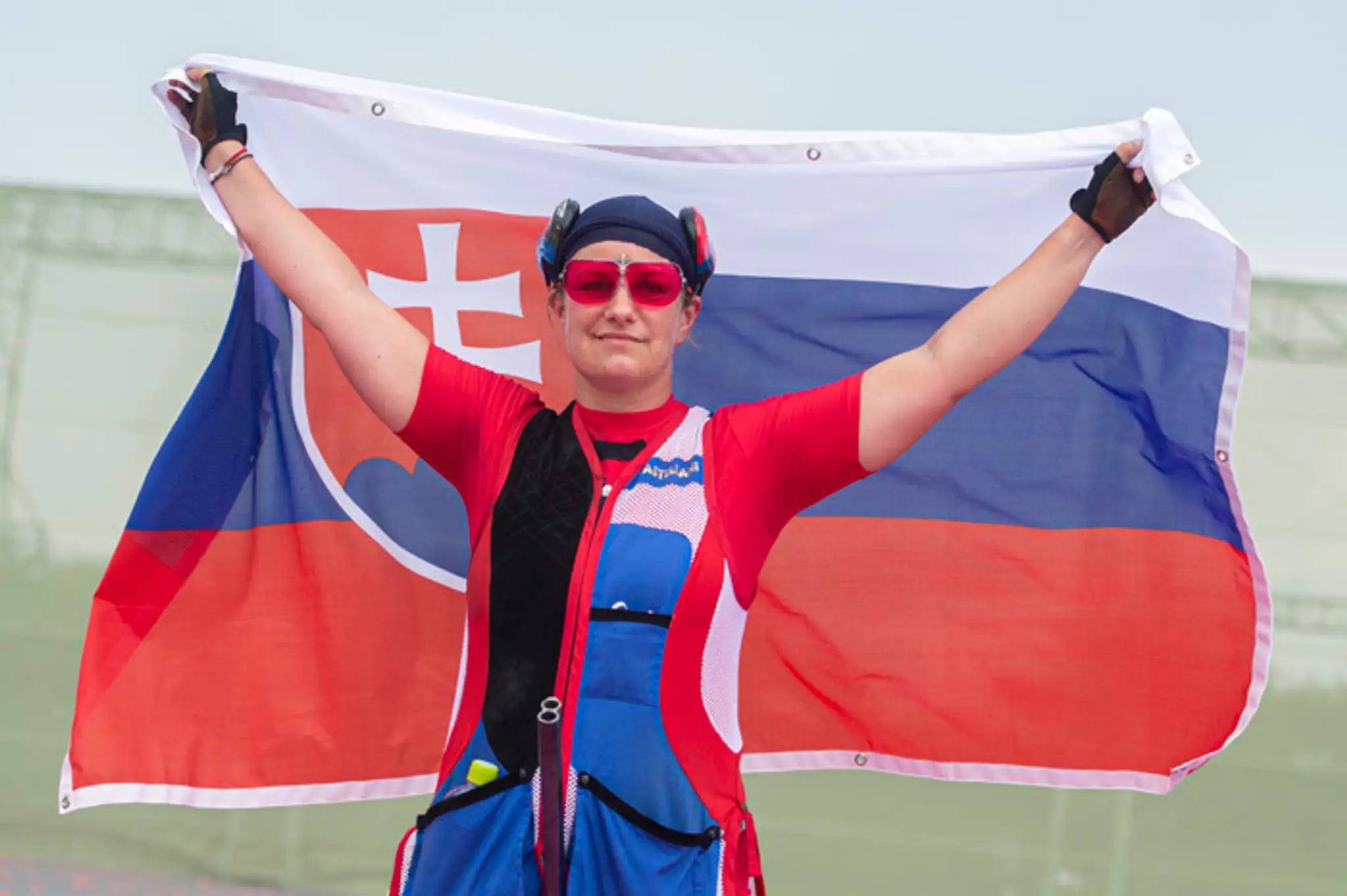 Zuzana Rehák Štefečeková pózuje so slovenskou vlajkou po zisku zlatej medaily v trape.