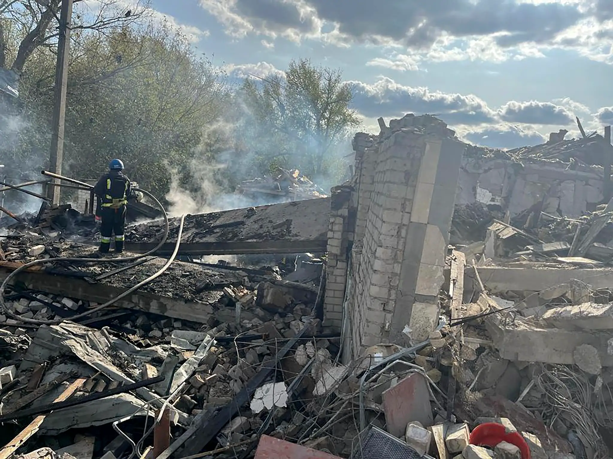 Na snímke hasiči hasia požiar po ruskom raketovom útoku na dedinu Hroza v Charkovskej oblasti