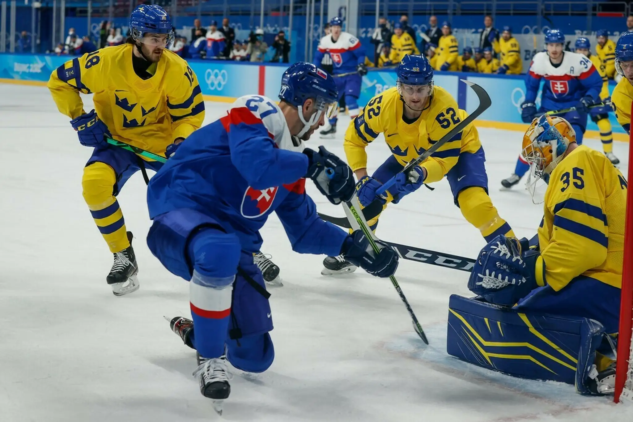 Švédsky gólman Magnus Hellberg zastavuje pokus Mareka Hrivíka v dueli na ZOH 2022.