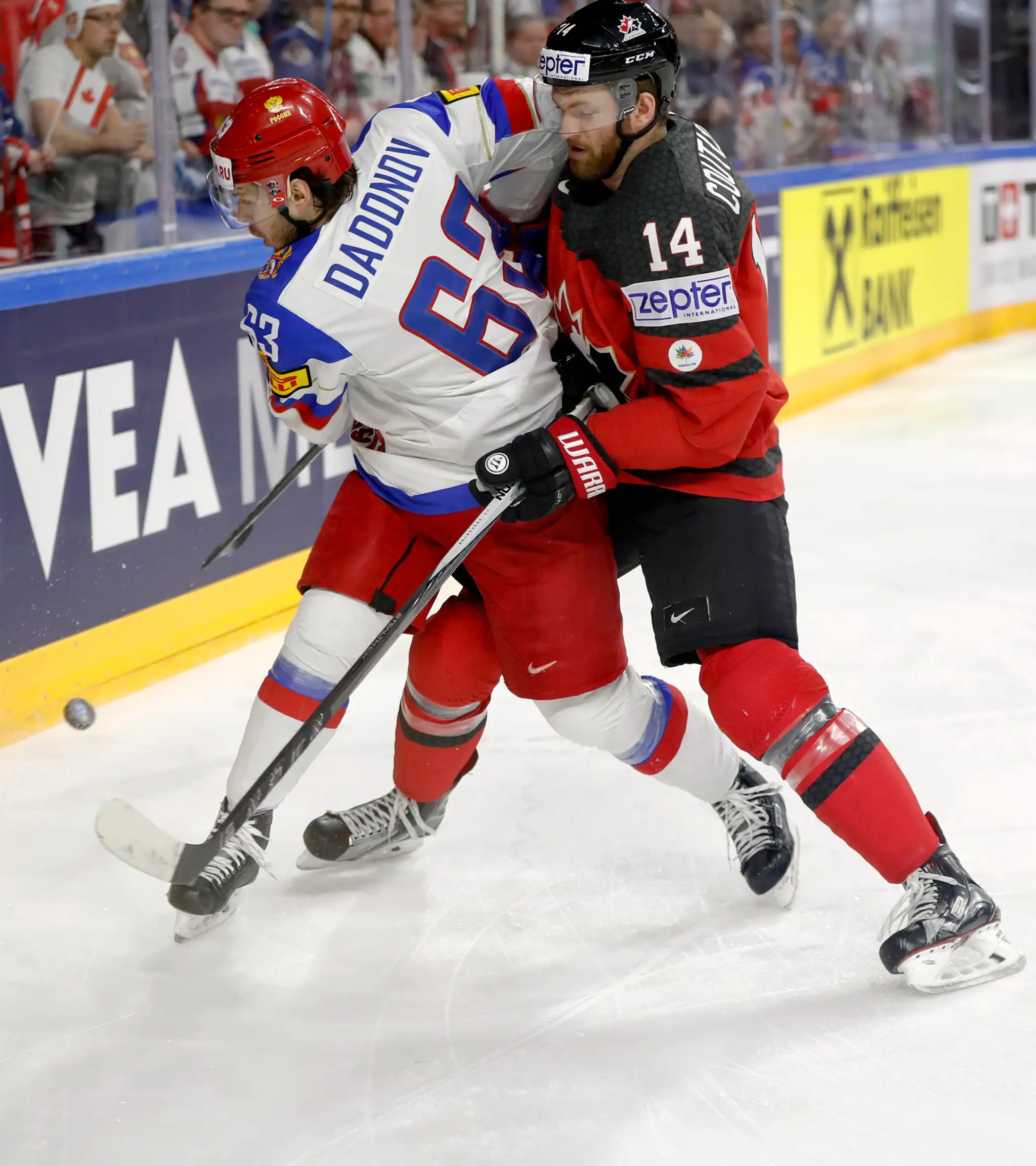 Sean Couturier (vpravo) z Kanady atakuje Jevgenija Dadonova z Ruska v semifinále MS 2017.