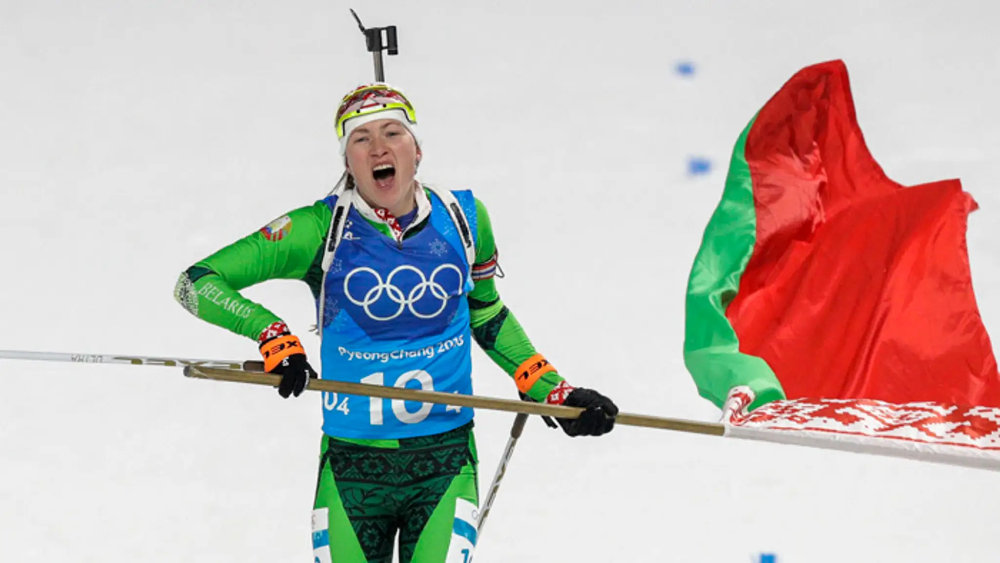 Zlatá Darja Domračevová s bieloruskou zástavou v cieli štafety žien 4x6 km na ZOH.