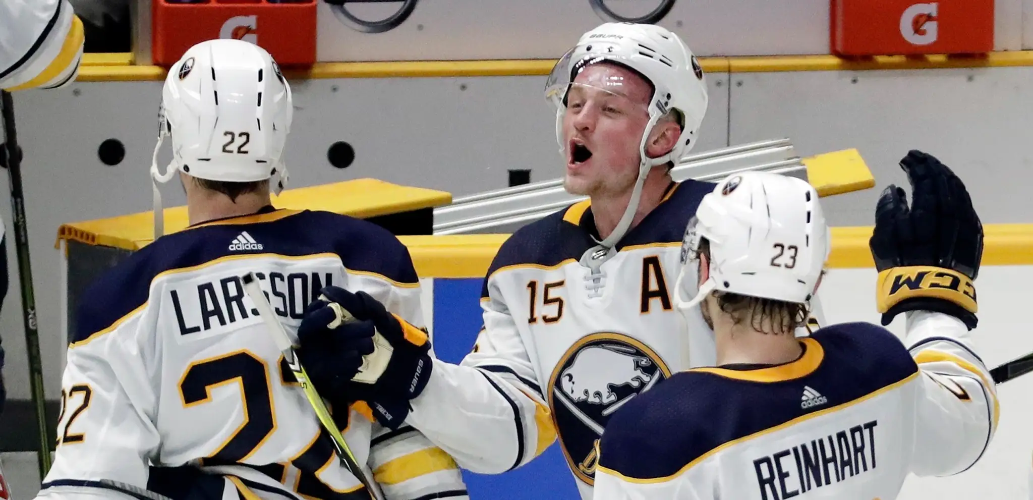 Jack Eichel (v strede) z Buffala sa teší so spoluhráčmi Johanom Larssonom (vľavo) a Samom Reinhartom.
