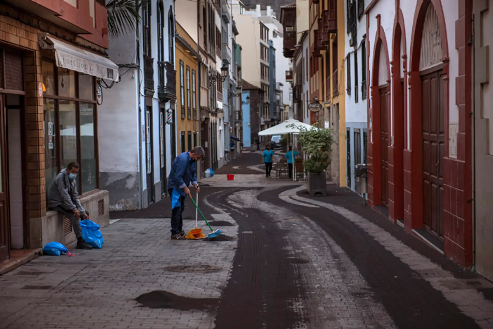Obyvatelia čistia ulicu od popola zo sopky La Cumbre Vieja na španielskom ostrove La Palma.