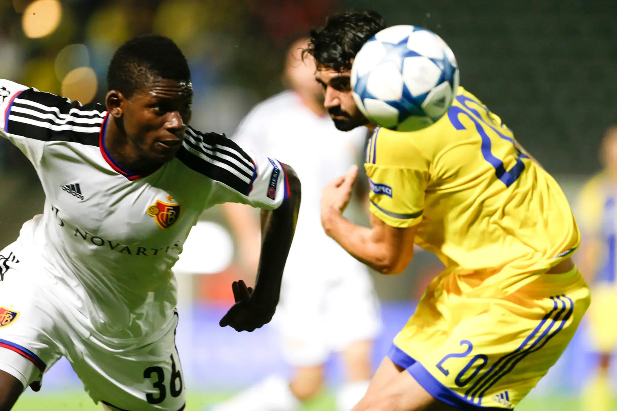Futbalista FC Bazilej Breel Embolo a hráč Maccabi Tel Aviv Omri Ben Harush bojujú o loptu.