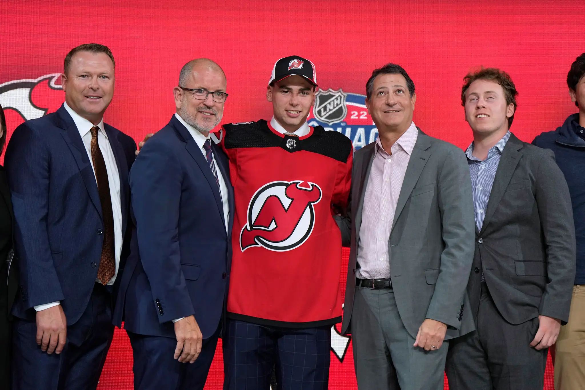 Šimon Nemec v drese New Jersey s predstaviteľmi klubu na drafte 2022.