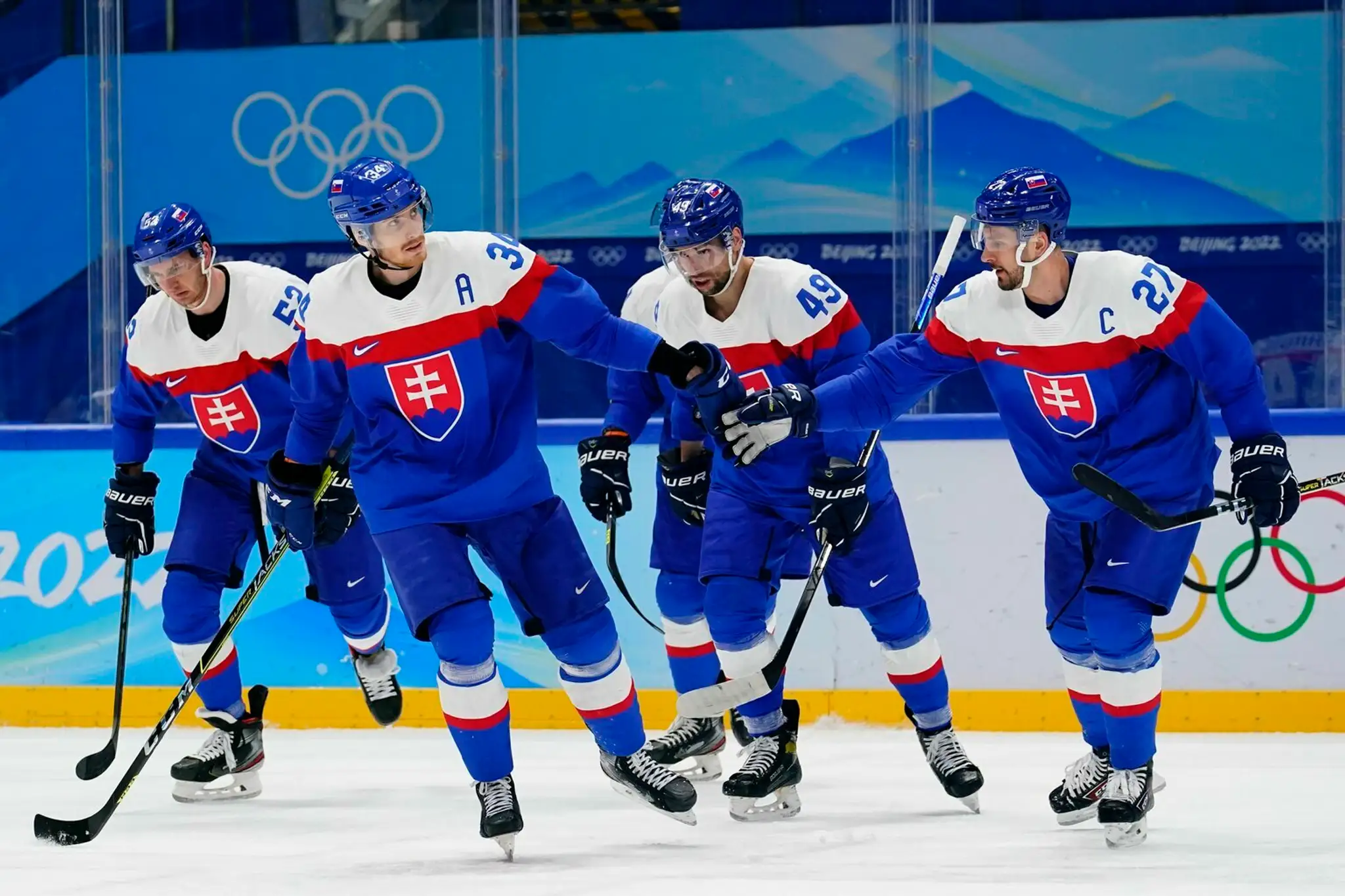 Hráči Slovenska olsavujú gól v zápase s Lotyšskom na ZOH 2022.
