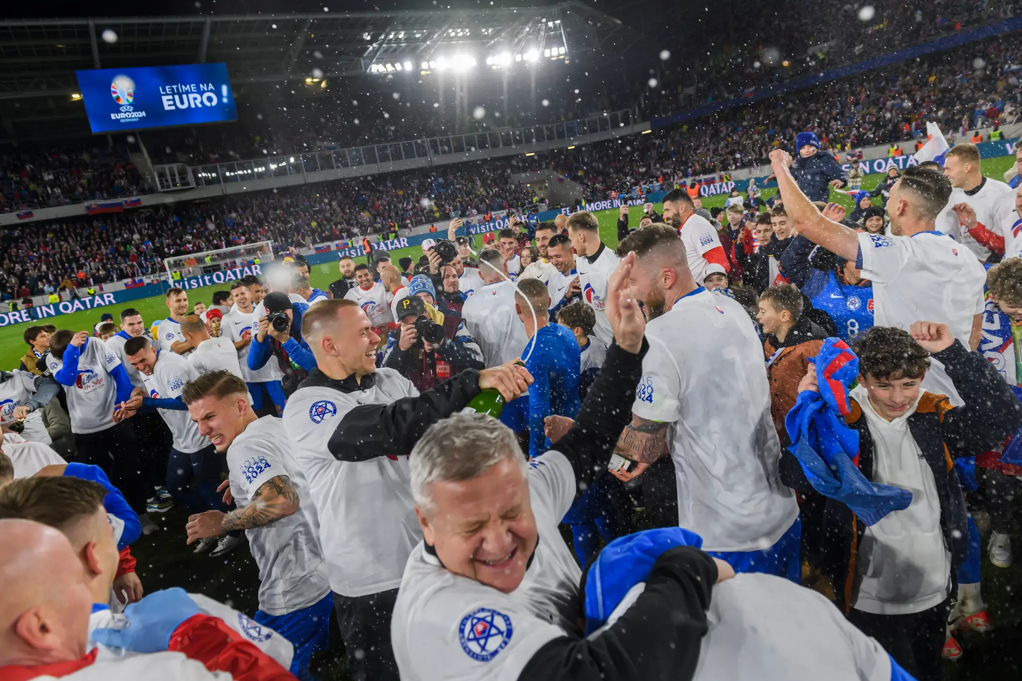 Futbalisti Slovenska a realizačný tím oslavujú postup na ME 2024 po zápase s Islandom.