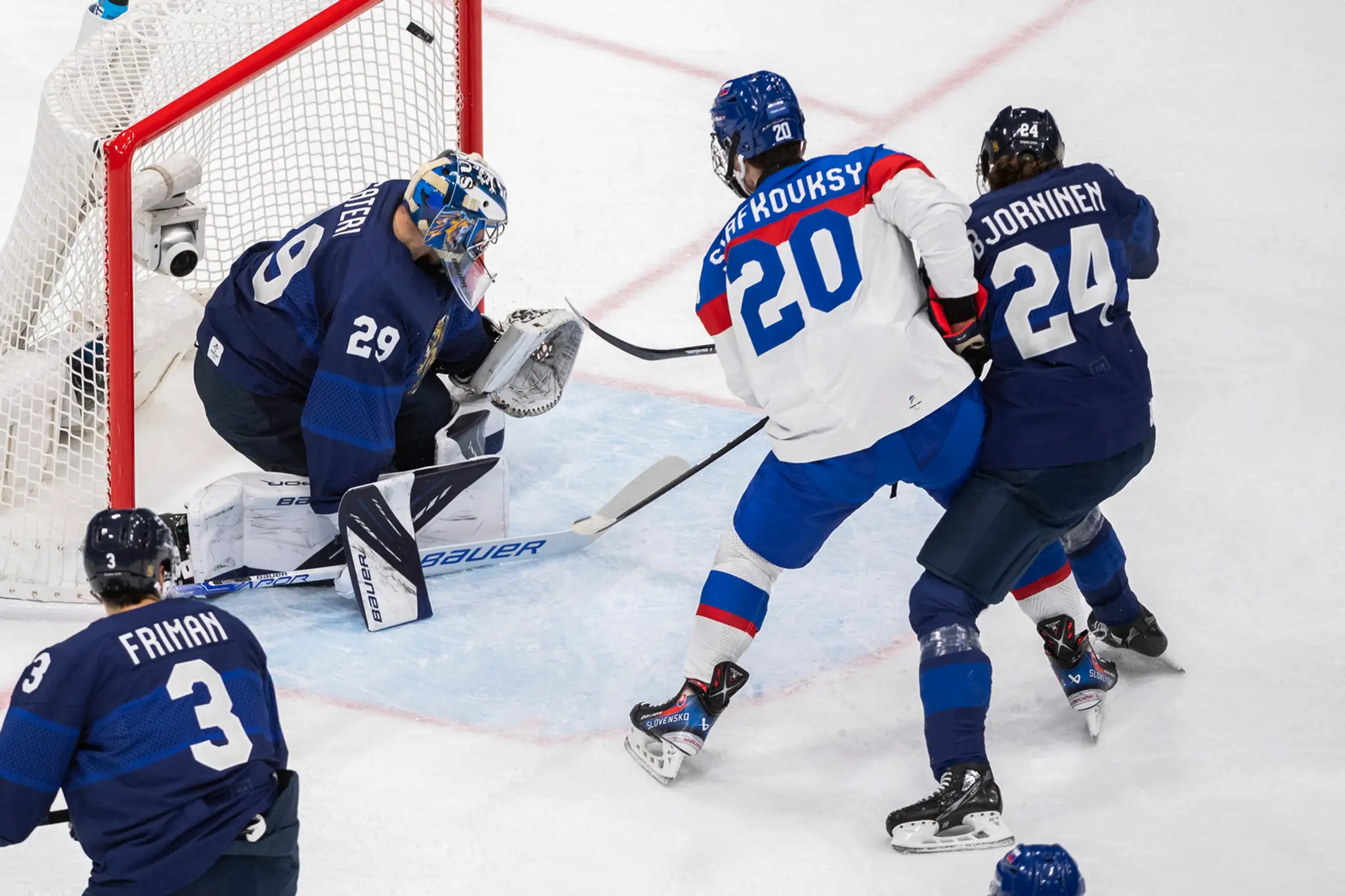Slovenský hokejista Juraj Slafkovský (druhý sprava) strieľa úvodný gól v zápase ZOH 2022 proti Fínsku.