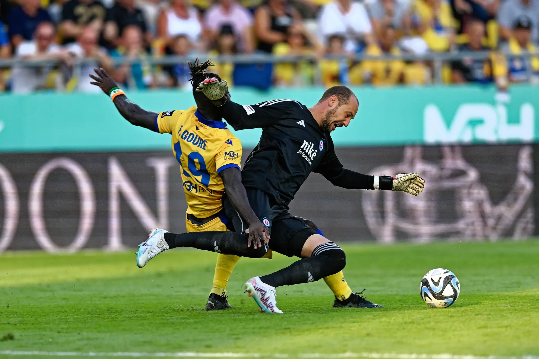Sprava kanadský brankár Slovana Milan Borja a hráč DAC Fernand Bi Irie Goure v zápase 7. kola Niké ligy.