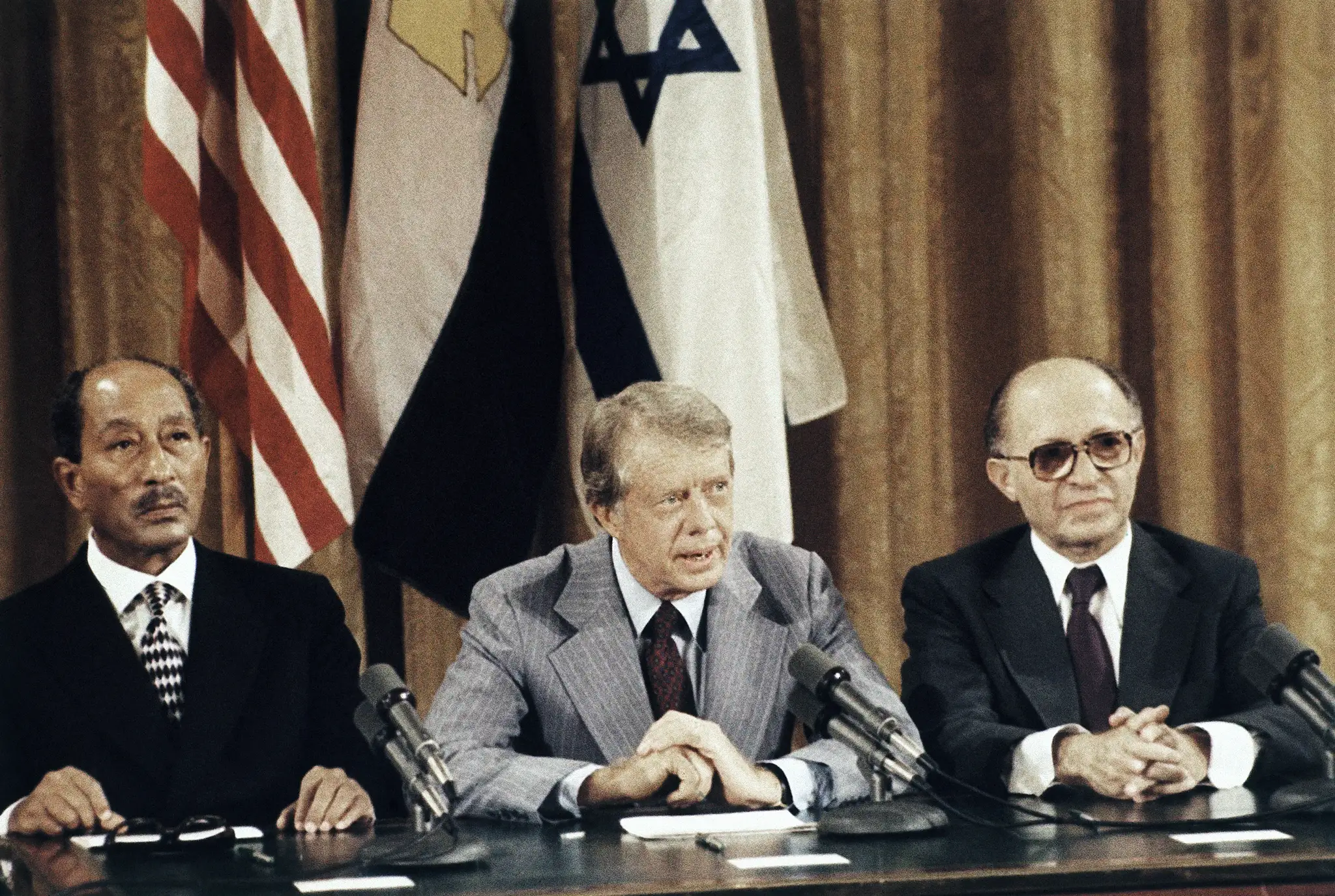 Prezident Jimmy Carter (v strede) je po boku izraelského premiéra Menachema Begina a egyptského prezidenta Anwara Sadata, keď čelia novinárom na záver ich diskusií o mierových krokoch na Blízkom východe v Carterovom